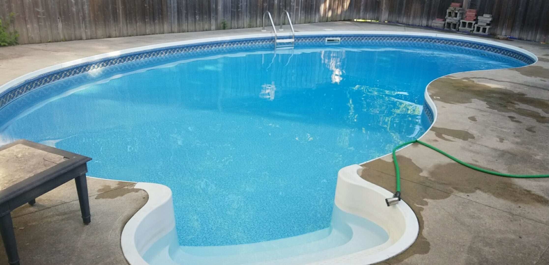 After renovation photo of a fully restored backyard swimming pool in Toronto. The new bright blue liner, clean water, and resurfaced edges highlight the professional pool transformation from old and damaged to modern and inviting. Expert pool renovation by local Toronto specialists.