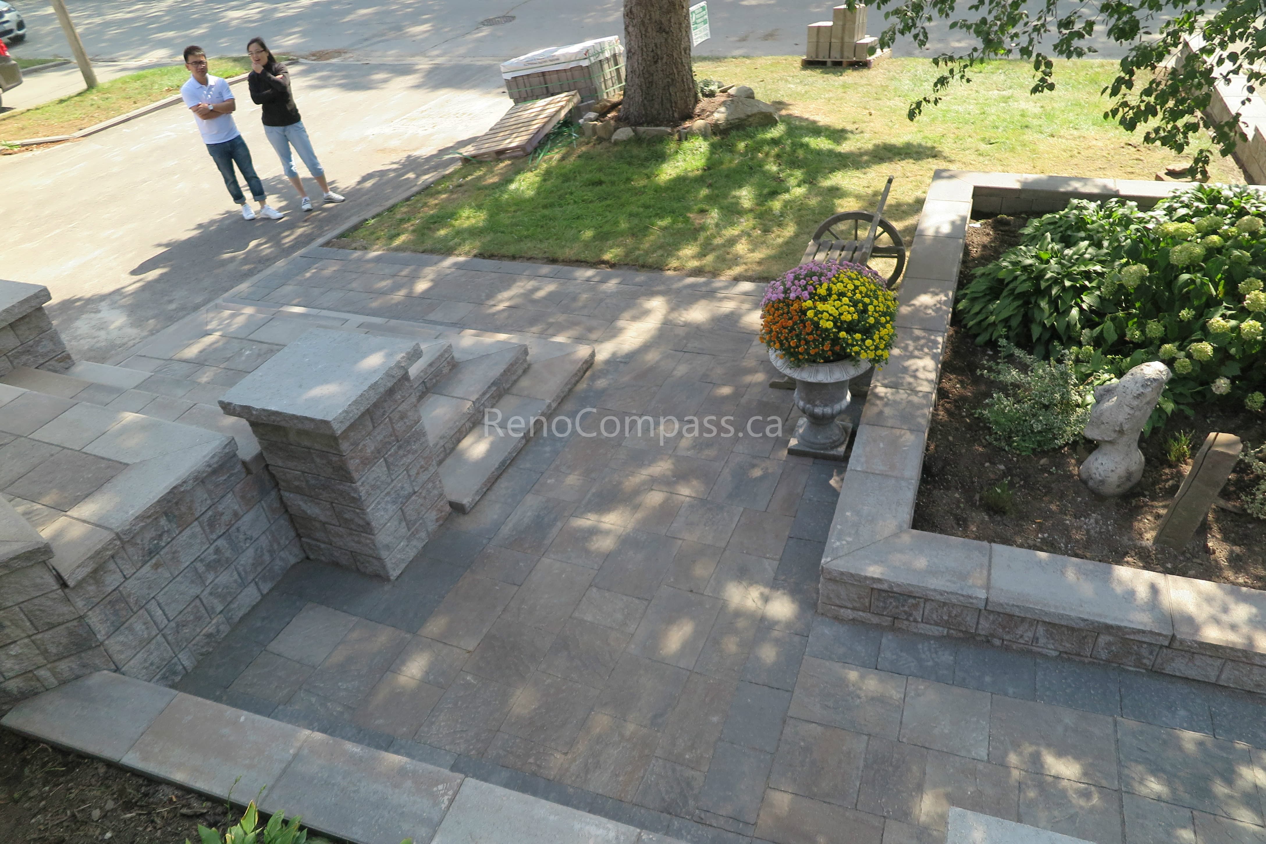 This Mississauga landscaping renovation showcases custom interlocking front entrance steps and landing patio designed for both visual impact and functionality. The multi-level stone layout creates a smooth transition from driveway to entrance while enhancing safety and flow. Premium interlocking pavers and stone columns add depth, structure, and a refined architectural feel to the exterior. Completed by Reno Compass Inc., this project highlights expert craftsmanship in residential interlocking and front yard landscaping design.