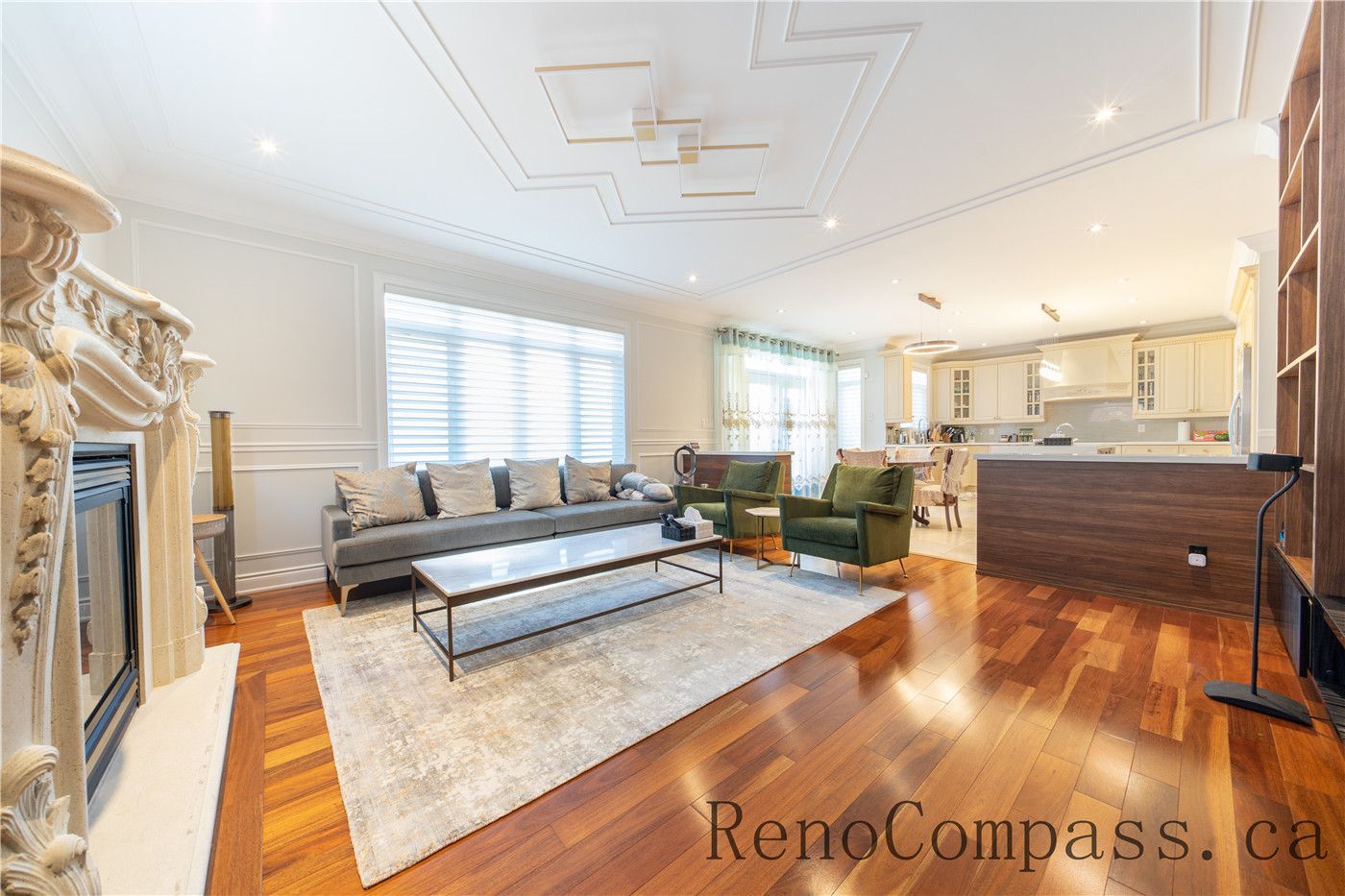 This Richmond Hill entire house interior renovation highlights an elegant open-concept dining and living area featuring rich hardwood flooring, custom ceiling detailing, and decorative columns. Large windows and a bright foyer connection enhance natural light and spatial flow throughout the home. The refined layout and timeless finishes create a warm, luxurious atmosphere, professionally completed by a leading Toronto renovation company focused on quality craftsmanship and modern functionality.