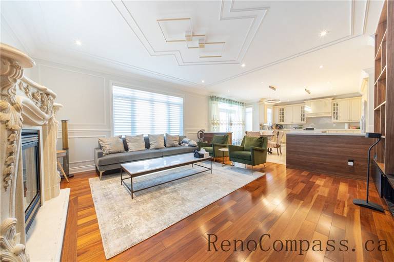This Richmond Hill entire house interior renovation highlights an elegant open-concept dining and living area featuring rich hardwood flooring, custom ceiling detailing, and decorative columns. Large windows and a bright foyer connection enhance natural light and spatial flow throughout the home. The refined layout and timeless finishes create a warm, luxurious atmosphere, professionally completed by a leading Toronto renovation company focused on quality craftsmanship and modern functionality.