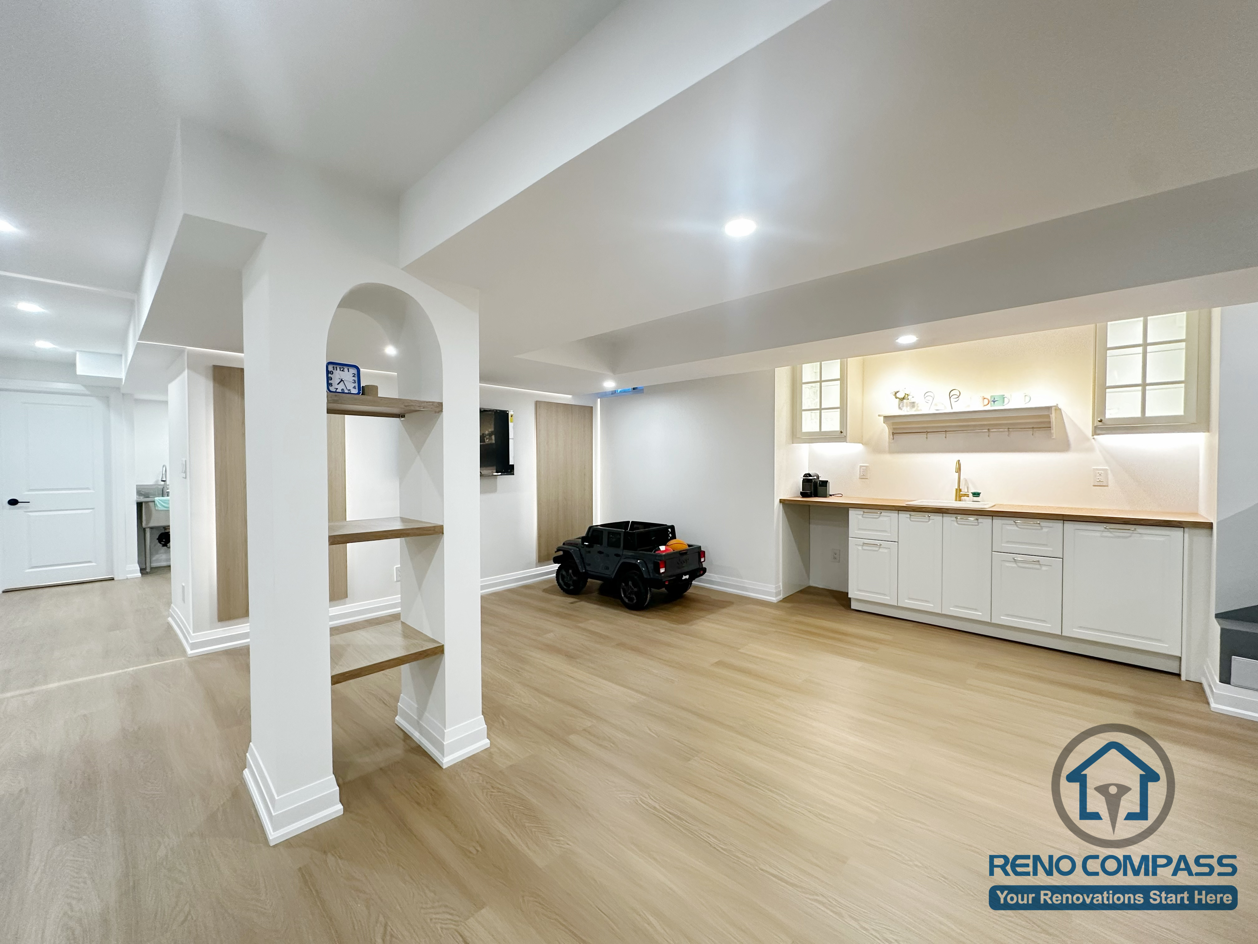 Open-concept basement renovation in Markham featuring light wood flooring, recessed ceiling lighting, and clean white support columns. The layout improves brightness, structural clarity, and flexibility for family living, recreation, and future customization.