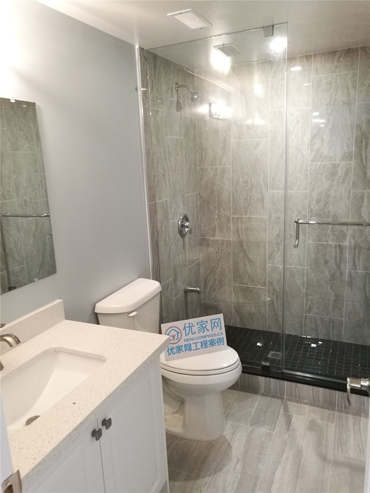 This image showcases a modern basement bathroom completed as part of a North York interior renovation. The space features a glass-enclosed shower, large-format tile finishes, a contemporary vanity, and clean plumbing fixtures. Neutral tones and durable materials enhance both functionality and visual appeal, creating a practical and comfortable bathroom design. This renovation reflects the quality workmanship of a professional Toronto renovation company serving the North York area.