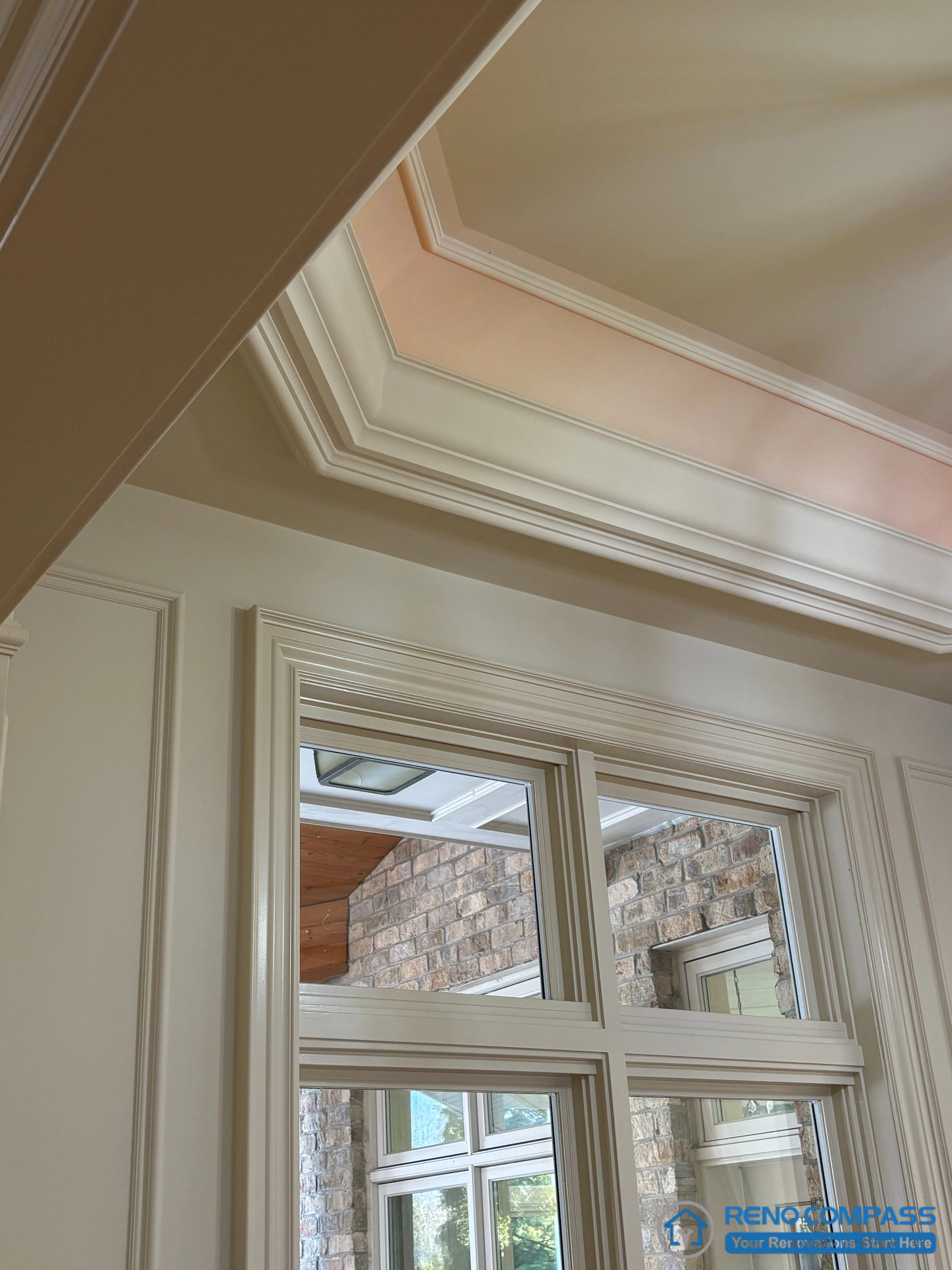 This image captures the junction between a European-style ceiling detail and classically framed windows, highlighting layered moulding, wall panelling, and precise trim alignment. The recessed ceiling treatment is carefully proportioned to the window height, reinforcing architectural hierarchy and visual order. Natural light interacts with the moulded surfaces, revealing depth and craftsmanship without relying on decorative excess. This detail view demonstrates refined construction and disciplined detailing within a high-end Richmond Hill interior renovation grounded in traditional European architectural principles.