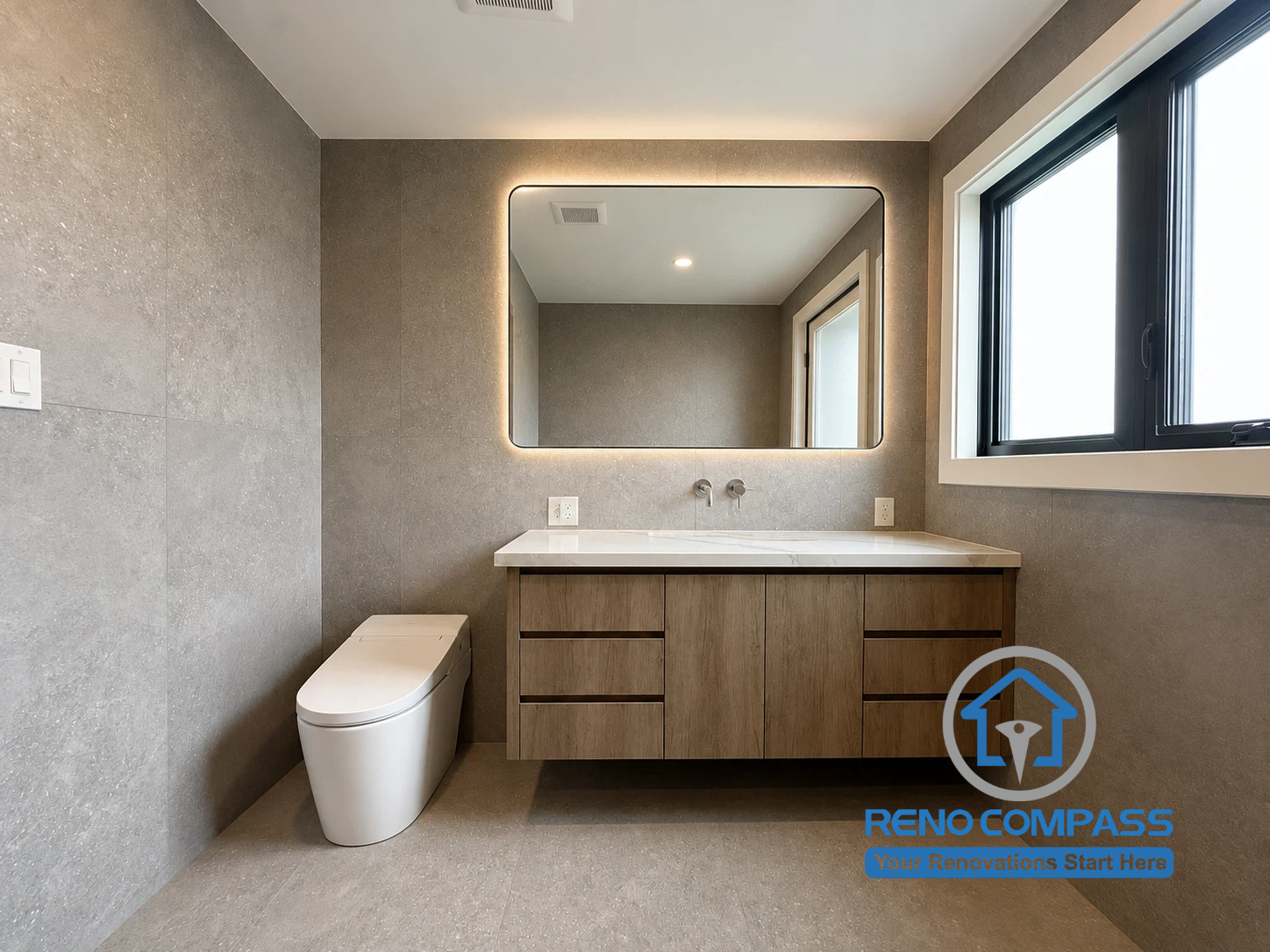This modern ensuite bathroom features a floating vanity, integrated LED mirror, smart toilet, and large-format porcelain tiles for a clean and sophisticated appearance. The combination of warm wood tones and contemporary finishes creates a comfortable, spa-inspired retreat designed for modern living. Project completed by Reno Compass, serving Markham, Toronto, Richmond Hill, Vaughan, and the Greater Toronto Area.