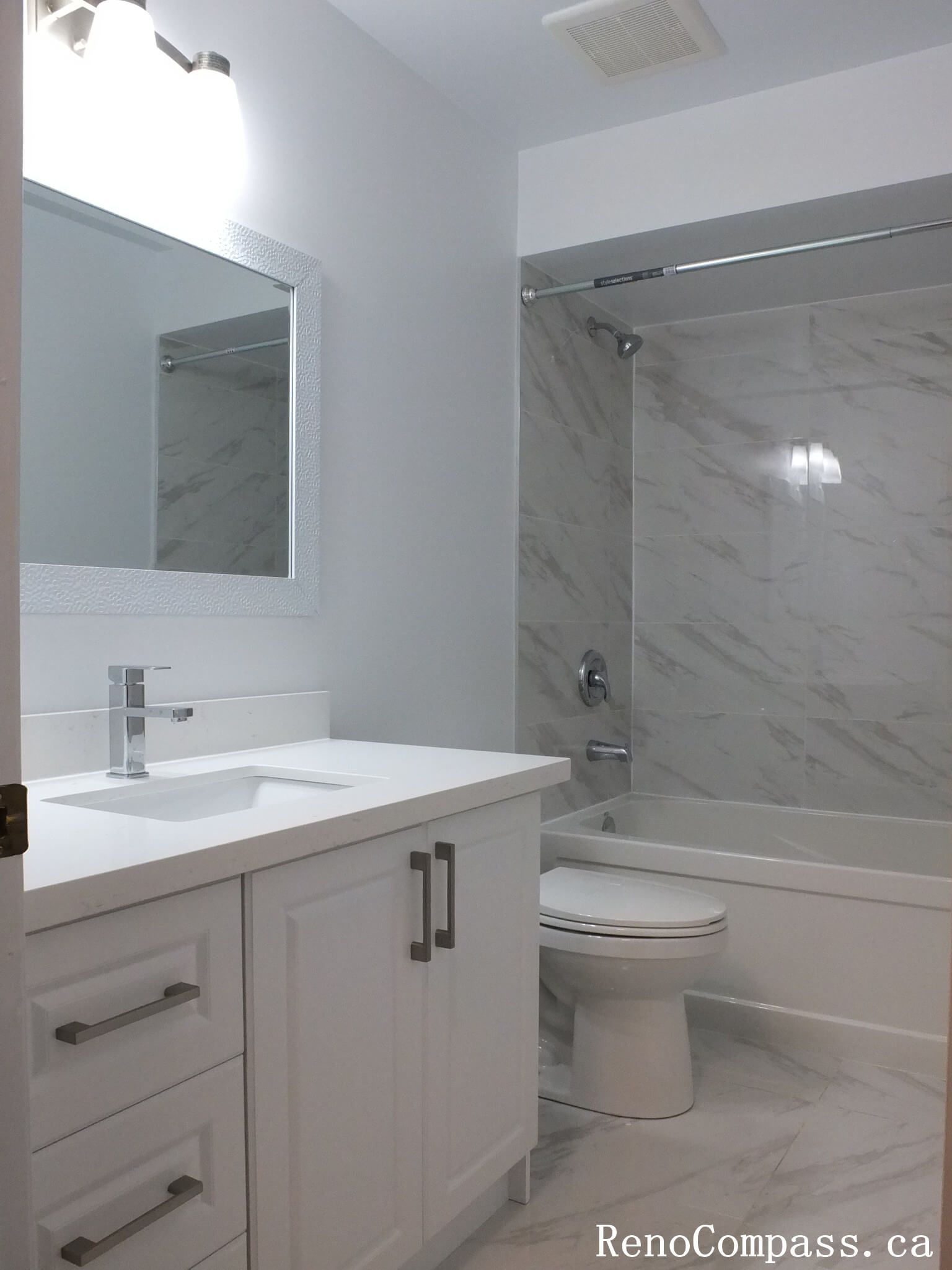 This Richmond Hill bathroom renovation features a clean tub-shower combination with marble-look wall tiles, modern glass doors, and a sleek vanity. Completed by a professional Toronto renovation company, the layout maximizes functionality while maintaining a bright and contemporary aesthetic. Neutral finishes and durable materials create a fresh, low-maintenance bathroom designed for everyday comfort and long-term use.