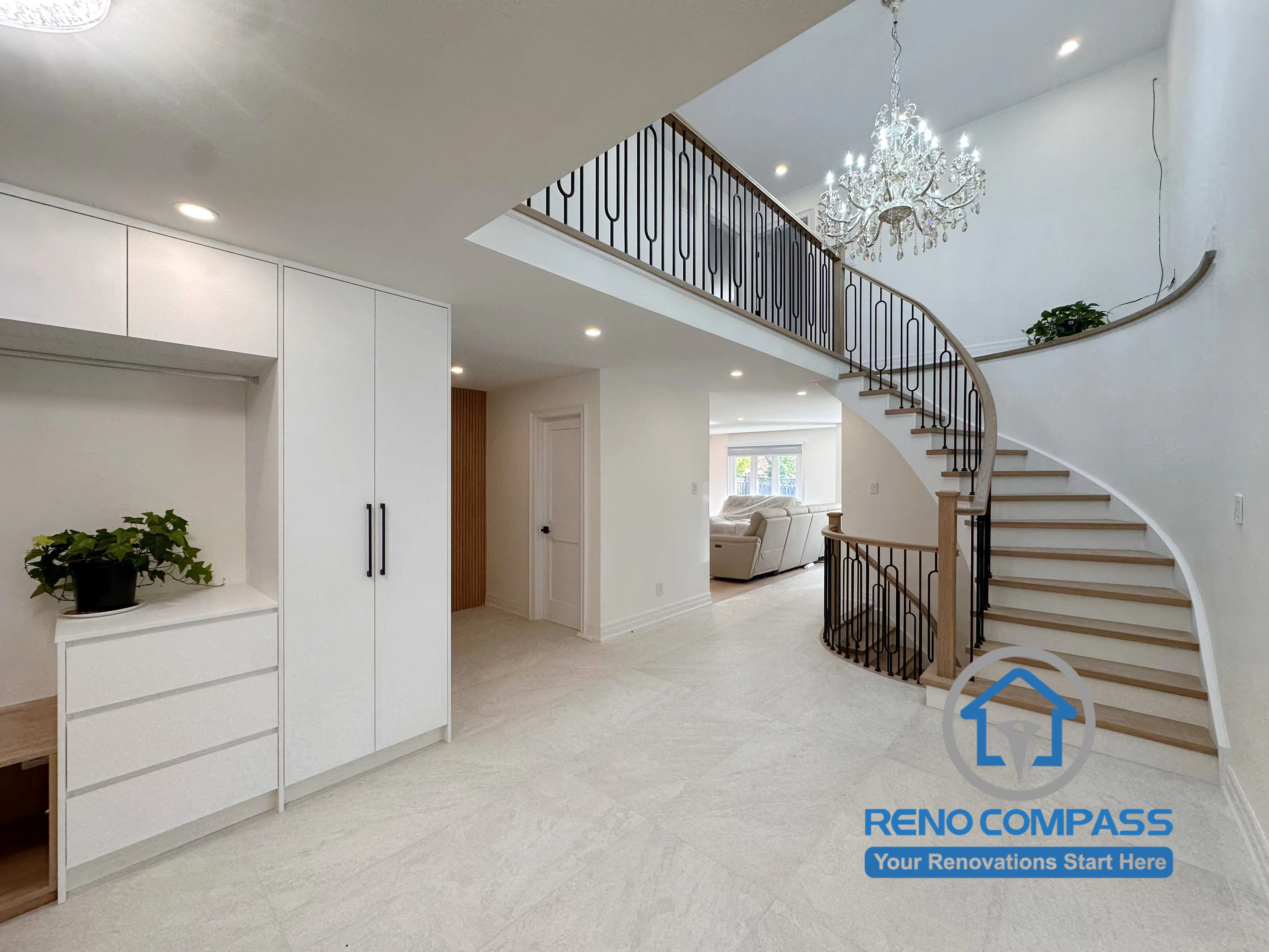 A custom mudroom with built-in storage seamlessly integrated into a luxury curved staircase and grand foyer during a whole home renovation in Markham, Ontario. This modern interior design features custom cabinetry, elegant lighting, premium finishes, and an open-concept layout by Reno Compass.