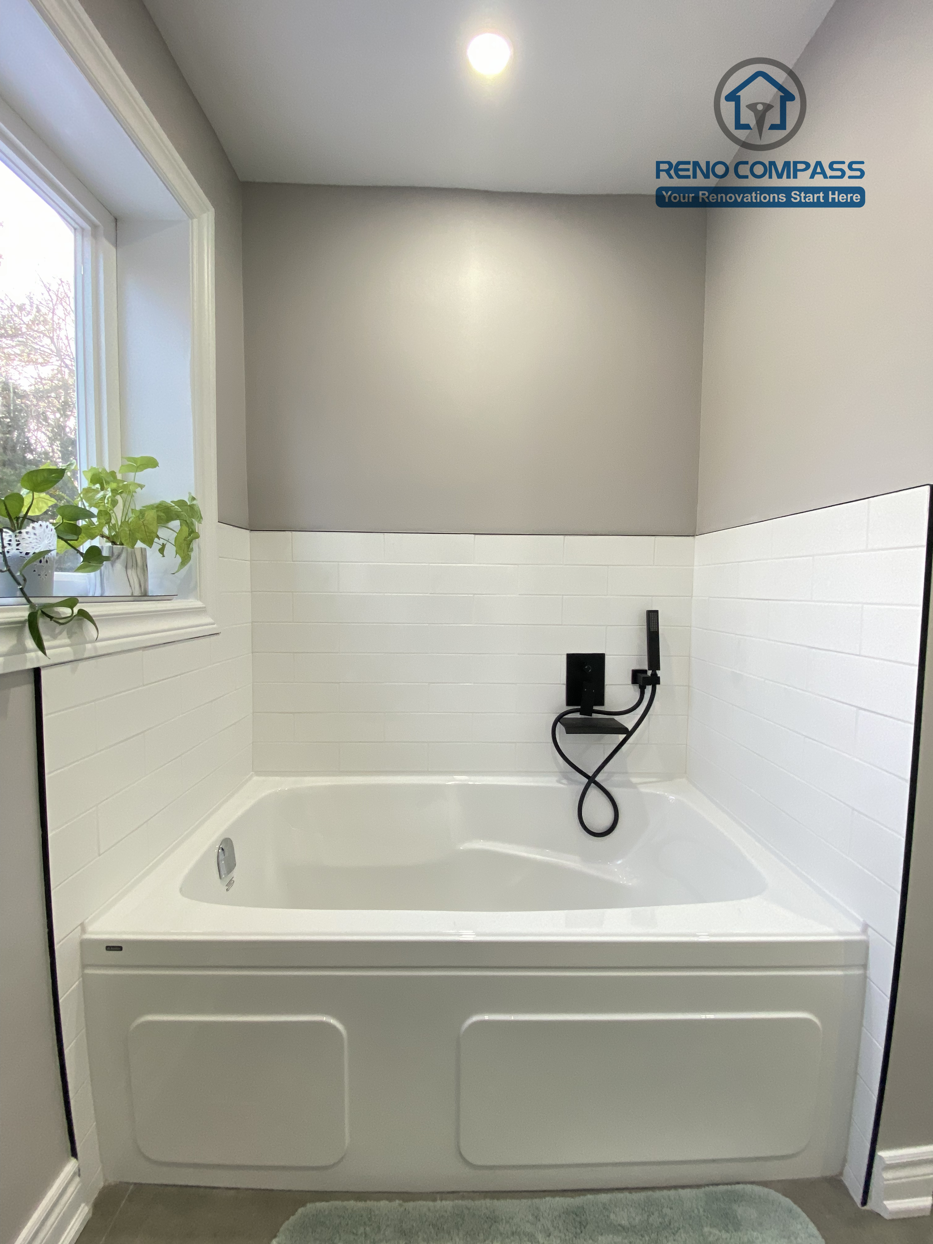 This North York bathroom renovation showcases a clean built-in bathtub paired with matte black fixtures and classic white subway tile walls. Natural light from the window enhances the soft gray palette, creating a calm and functional bathing space designed and completed by a Toronto renovation company focused on durability, comfort, and timeless design.