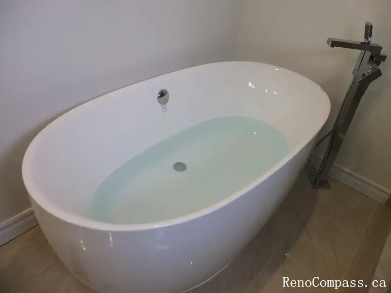 Bathroom renovation in North York featuring a freestanding bathtub with floor-mounted faucet and clean, minimalist layout. This Toronto interior renovation highlights comfort-focused design, smooth circulation, and durable finishes suited for modern residential bathrooms.