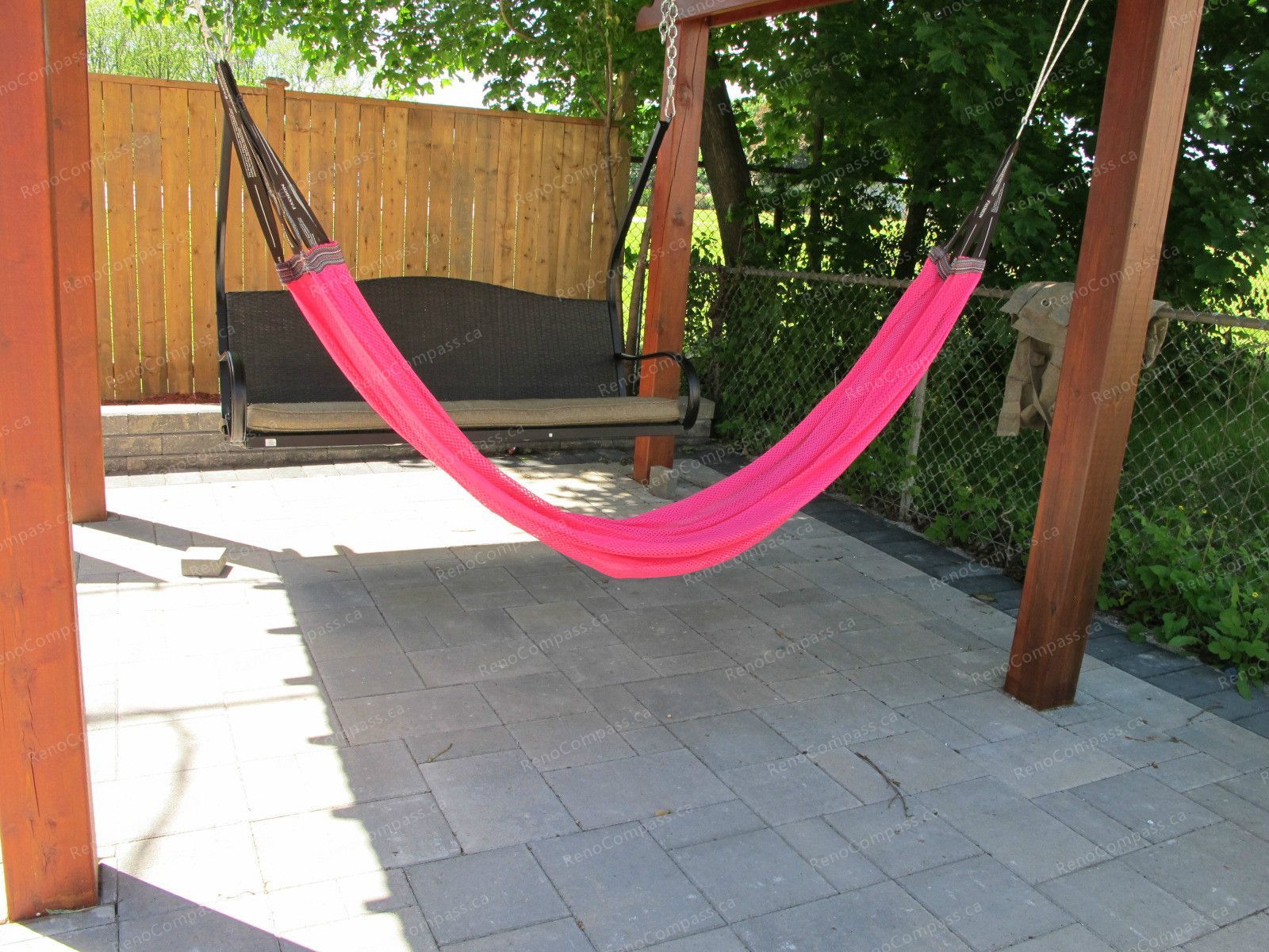 This Markham backyard landscaping project features a custom-built wooden pergola combined with a professionally installed interlock patio. The outdoor space is designed for comfort and leisure, complete with a hammock and swing seating area, creating a perfect backyard retreat. The durable stone paving enhances functionality while maintaining a clean and modern look. Completed by Reno Compass Inc., this project highlights expert craftsmanship in outdoor garden design and interlock installation, transforming the backyard into a stylish and inviting living space.