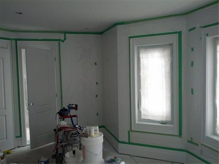 This image showcases a professional interior wall painting project in Toronto, highlighting detailed surface preparation before painting. Windows, trims, and edges are carefully masked to ensure clean paint lines and a flawless finish. Our experienced Toronto painting and renovation team focuses on precision, protection, and high-quality workmanship to deliver smooth, modern interior walls for residential spaces.