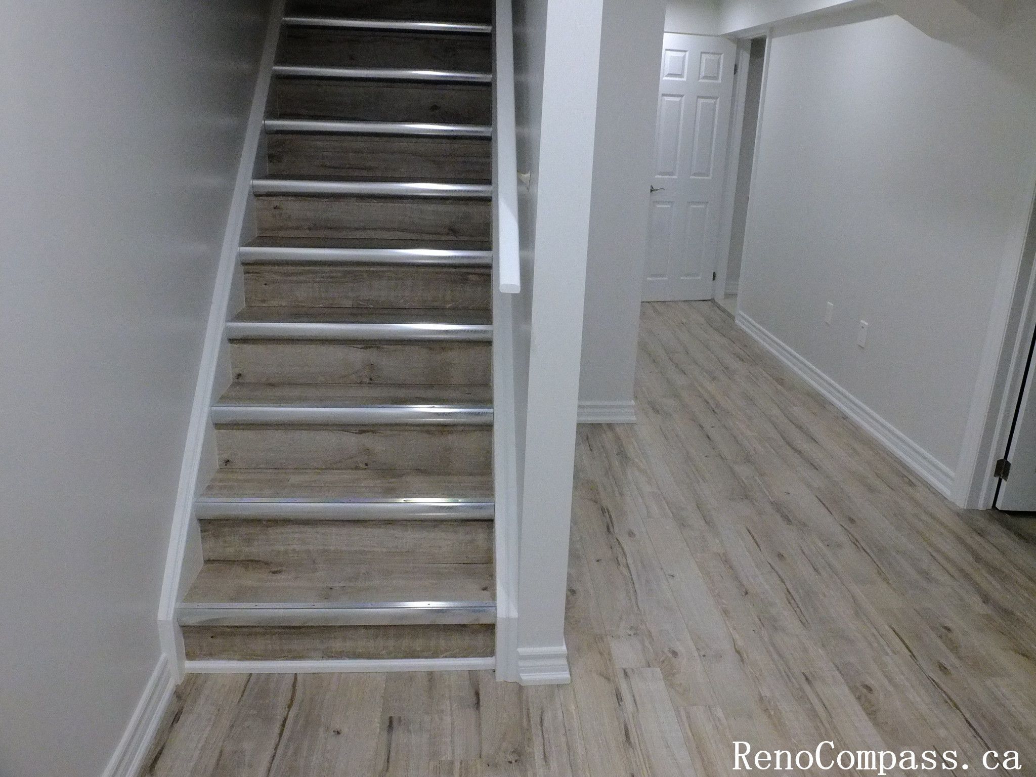 Stylish basement staircase with light wood steps and white trim, part of a full Richmond Hill basement renovation project by Reno Compass