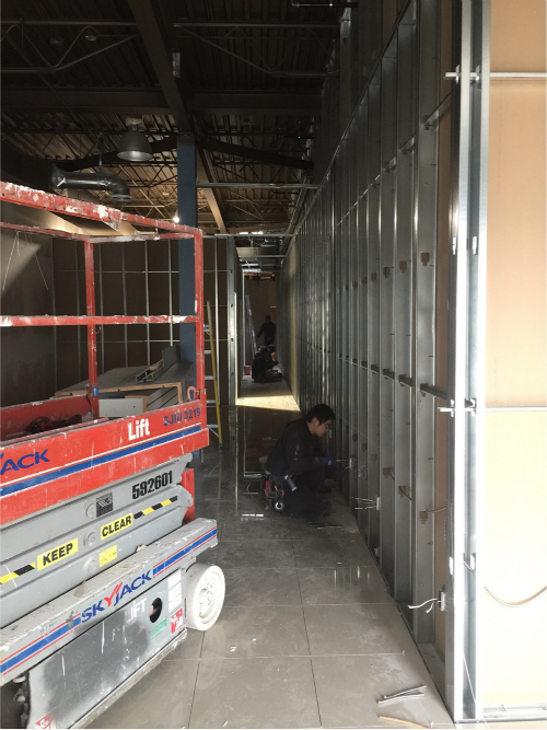 该图片记录一万尺娱乐中心室内改造施工阶段，由专业多伦多装修公司执行商业空间结构重建工程。现场正在进行轻钢龙骨隔墙搭建、天花结构调整及机电管线预留，为后续空间功能分区与装饰工程做好基础。大型商业娱乐空间翻新需兼顾承重结构、安全规范与商业动线规划，施工团队通过标准化流程与专业技术，确保工程稳步推进并为最终高品质娱乐空间呈现奠定坚实基础。