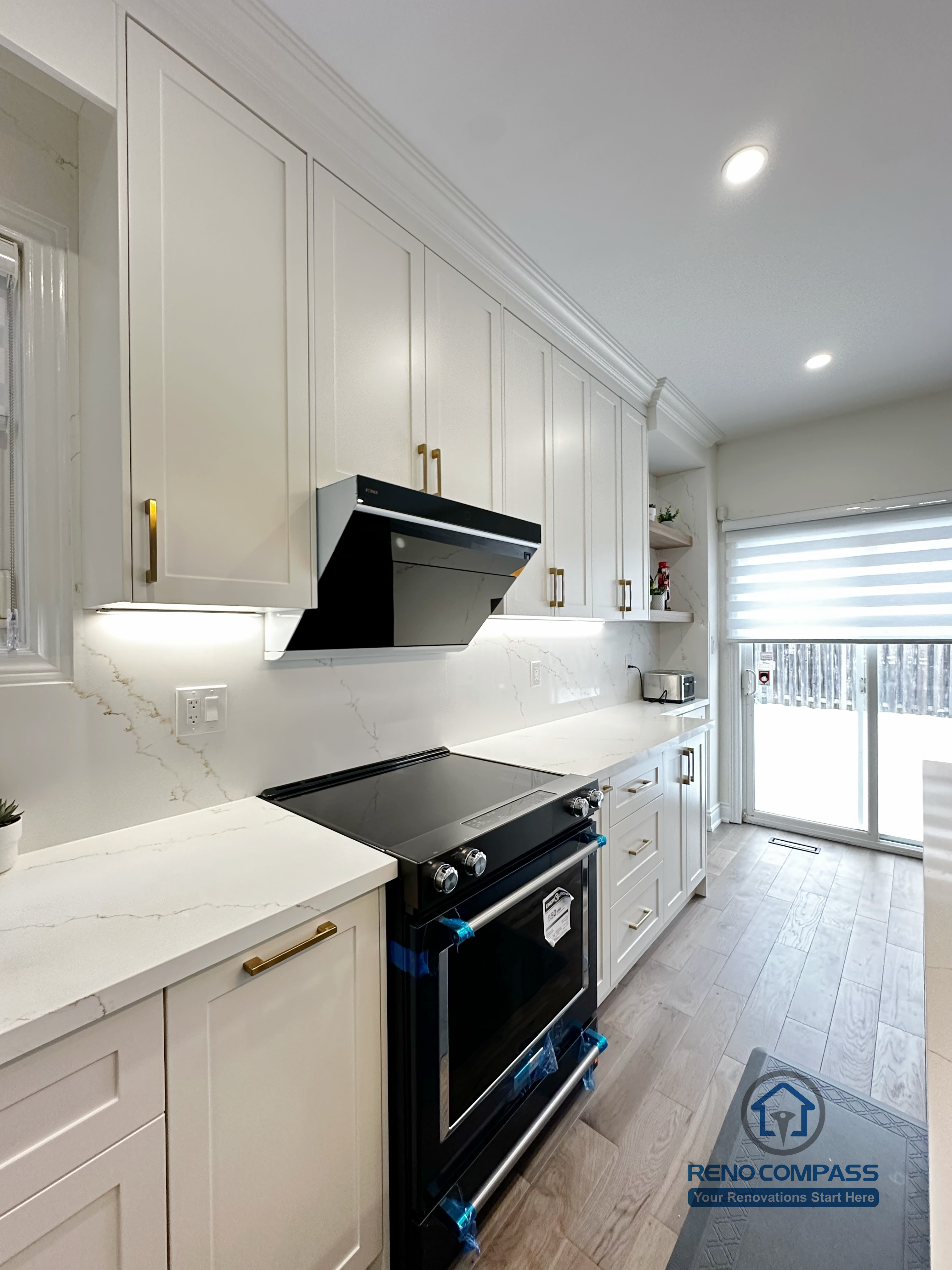 Interior renovation in Markham featuring custom full-height cabinetry, quartz countertops, integrated cooktop, and modern range hood. Clean lines, recessed lighting, and durable finishes create an efficient and refined kitchen workspace.