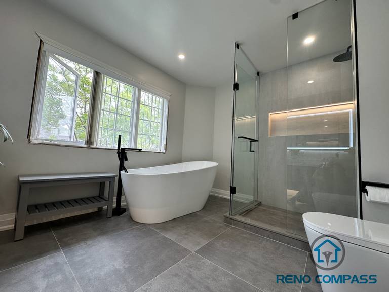 A luxurious Oakville bathroom featuring a spacious walk-in shower with frameless glass and a built-in niche, paired with a freestanding bathtub. This layout balances open design with functional storage, creating a spa-like retreat perfect for relaxation and everyday use.