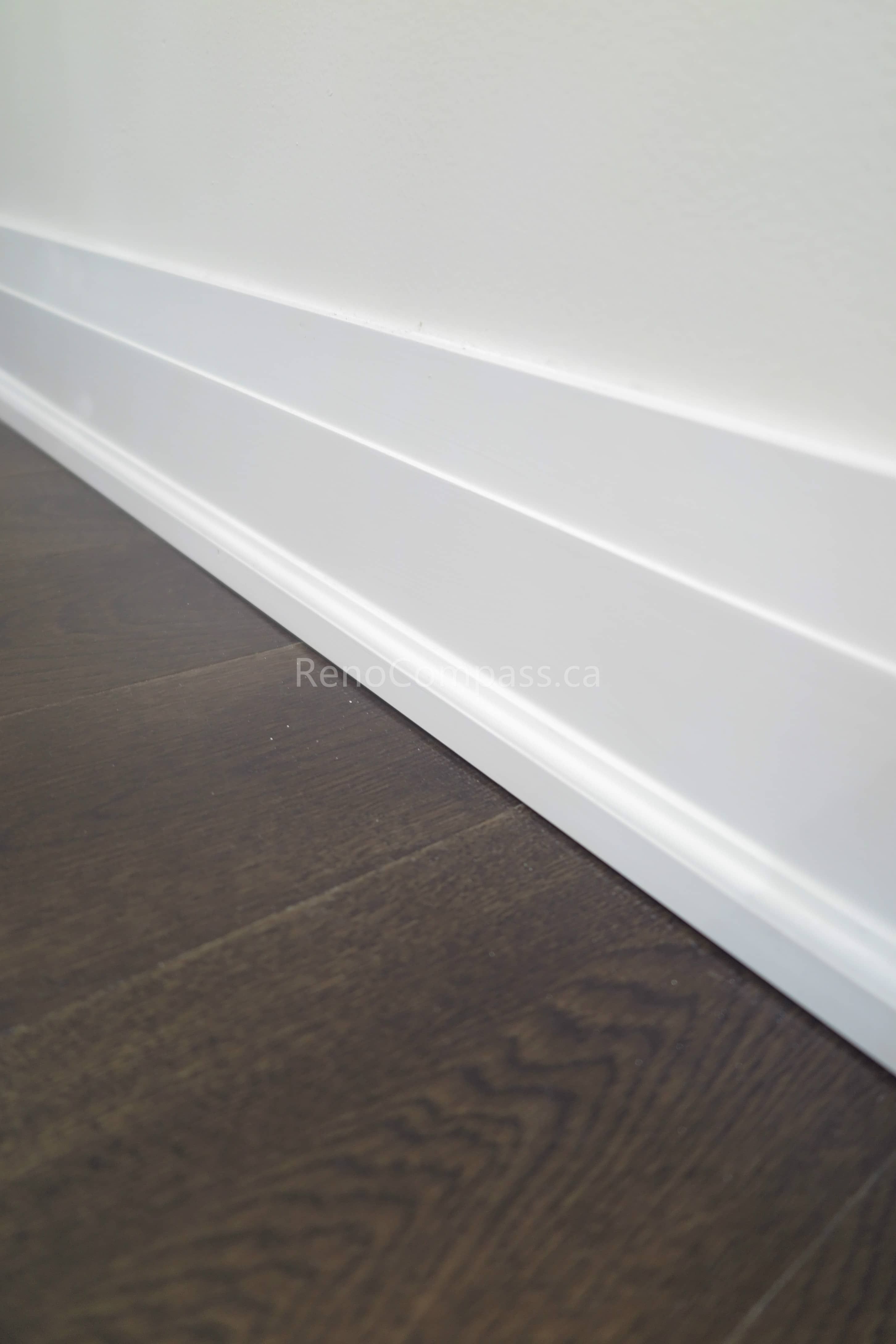 This Toronto interior renovation highlights clean white modern baseboard installation paired with premium dark hardwood flooring. The precise trim work and seamless finishing enhance the home’s contemporary style while adding durability and value. Completed by a professional Toronto renovation contractor, this detail reflects Reno Compass Inc.’s commitment to quality craftsmanship and refined interior finishing.