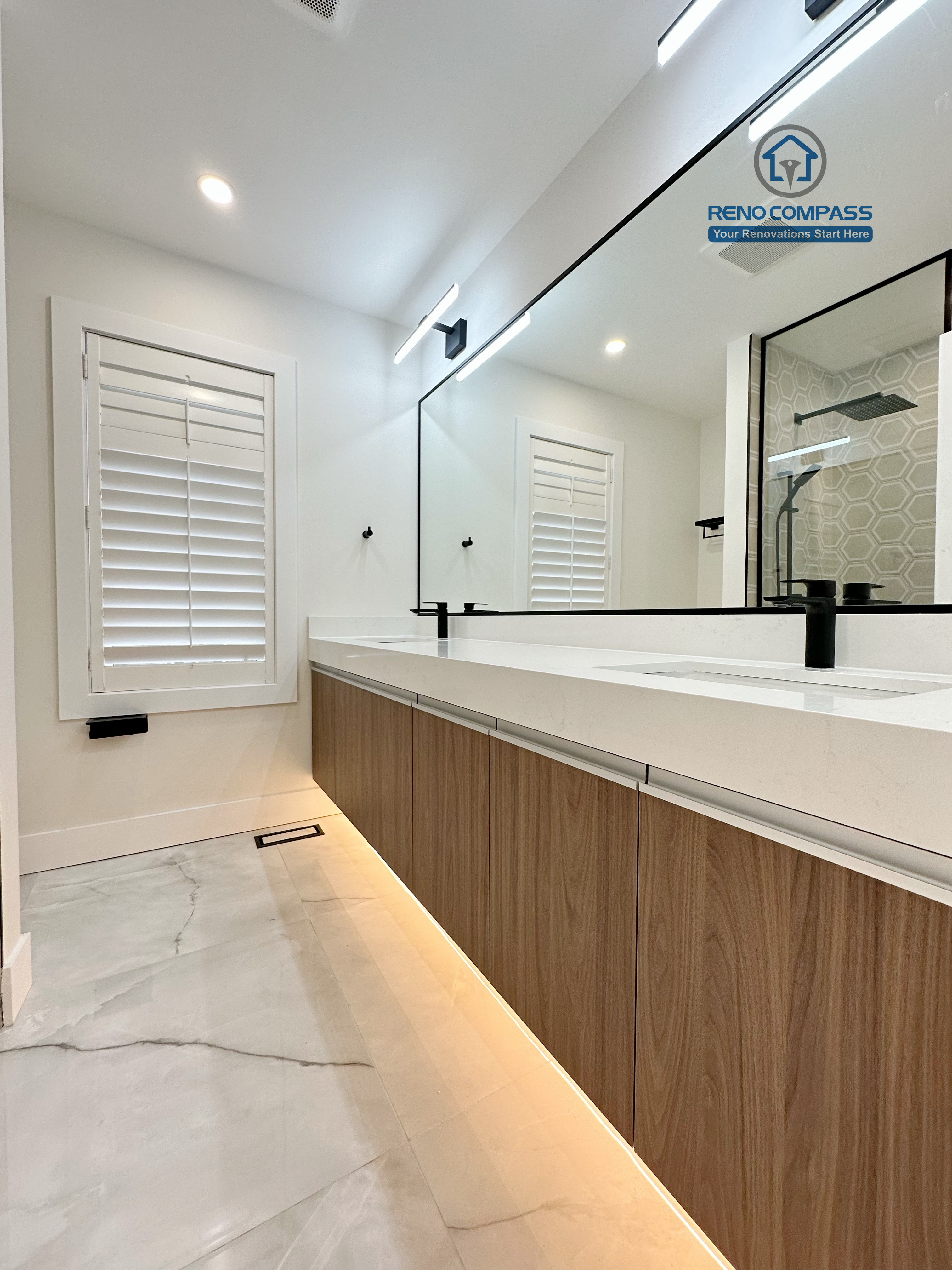 Modern bathroom renovation in Richmond Hill featuring a long floating double-sink vanity, integrated LED under-cabinet lighting, full-width mirror, and sleek black fixtures for a refined and contemporary finish.