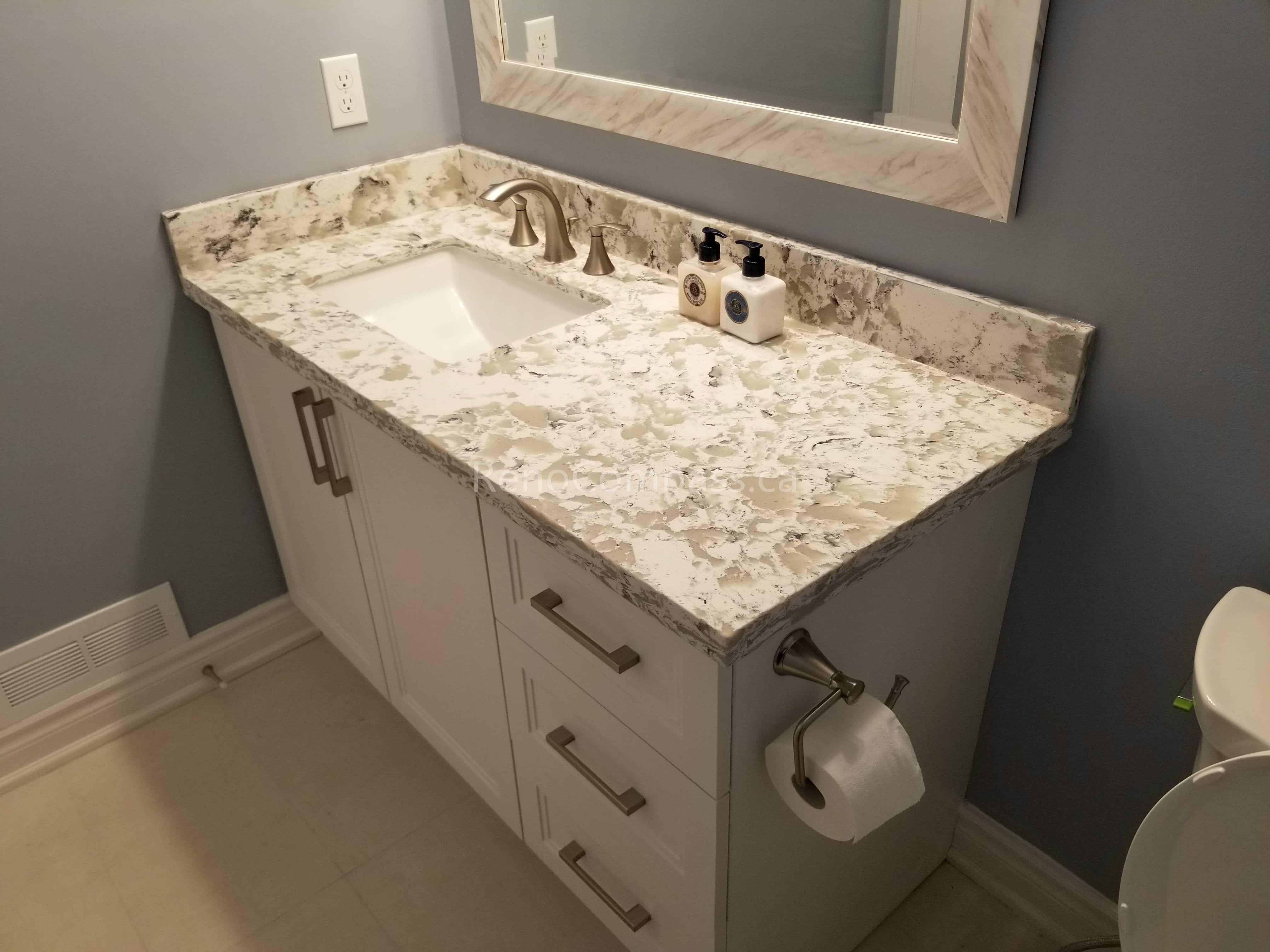 This Mississauga bathroom renovation showcases a custom vanity with a premium quartz countertop, modern undermount sink, and brushed metal fixtures. The elegant stone surface adds durability and luxury, while the clean cabinetry design provides practical storage and a timeless contemporary look.

Completed by Reno Compass Inc., this bathroom upgrade combines high-quality materials, precise installation, and refined finishing details to create a stylish and functional everyday space.