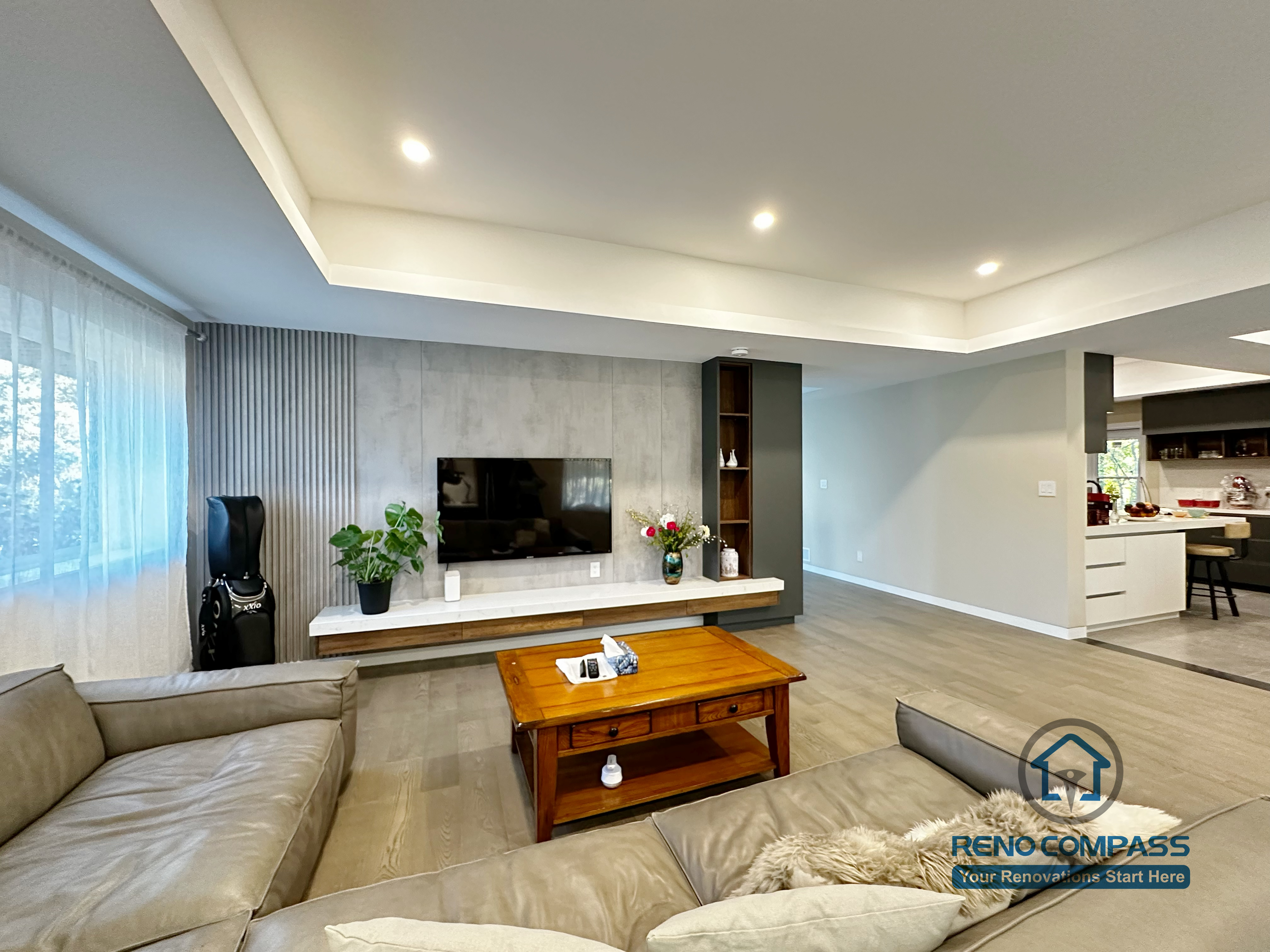 Open-concept living room completed as part of a North York interior renovation. This view highlights the seamless connection between the living area and adjacent spaces, featuring recessed ceiling lighting, wide-plank flooring, and a custom TV wall that anchors the room. Designed for clarity, flow, and everyday comfort by a professional Toronto renovation company.