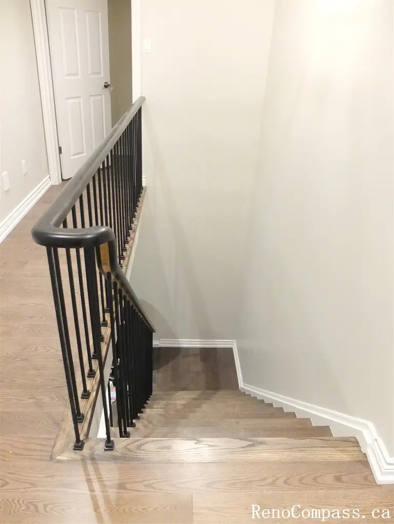 This staircase renovation is part of a North York interior renovation, featuring refinished hardwood stair treads paired with a black iron railing system. The clean lines and neutral wall tones create a seamless visual transition between floors while enhancing safety and durability. The staircase design prioritizes everyday use, proper handrail height, and consistent material finishes throughout the home. Completed by a Toronto renovation company, this stair renovation blends modern detailing with long-lasting construction standards.