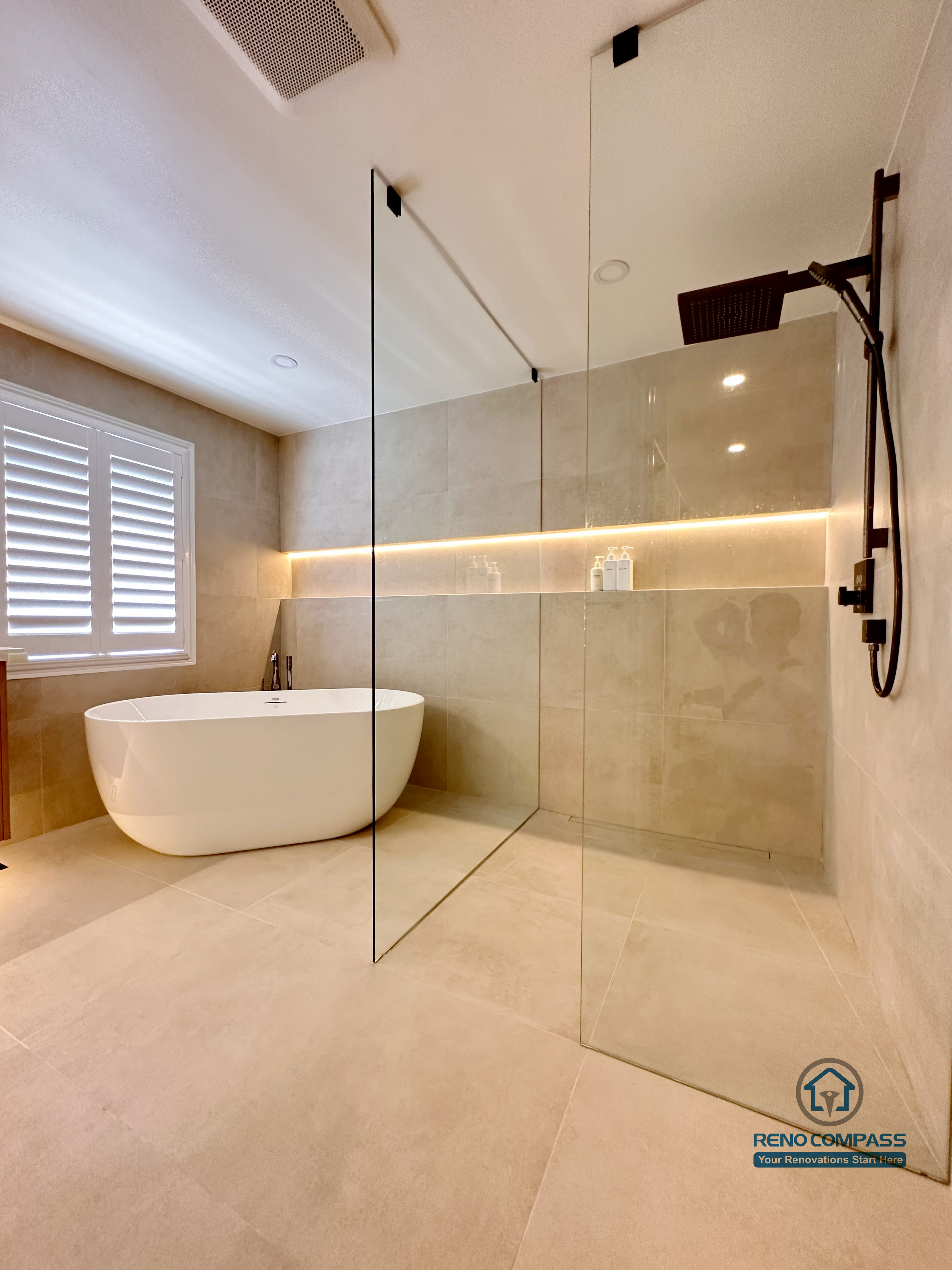 This Markham accessible bathroom renovation features a freestanding bathtub positioned within a barrier-free layout, allowing easy movement and step-free access. Large-format floor and wall tiles, integrated linear lighting, and a custom wood-tone vanity contribute to a calm, safe, and modern environment. Designed and built by a professional Toronto renovation company, Reno Compass Inc., the space prioritizes accessibility, comfort, and long-term usability.