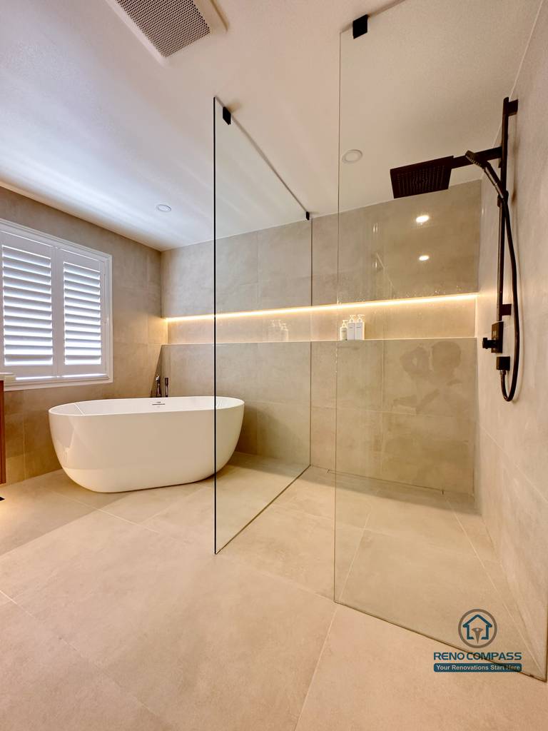 This Markham accessible bathroom renovation features a freestanding bathtub positioned within a barrier-free layout, allowing easy movement and step-free access. Large-format floor and wall tiles, integrated linear lighting, and a custom wood-tone vanity contribute to a calm, safe, and modern environment. Designed and built by a professional Toronto renovation company, Reno Compass Inc., the space prioritizes accessibility, comfort, and long-term usability.