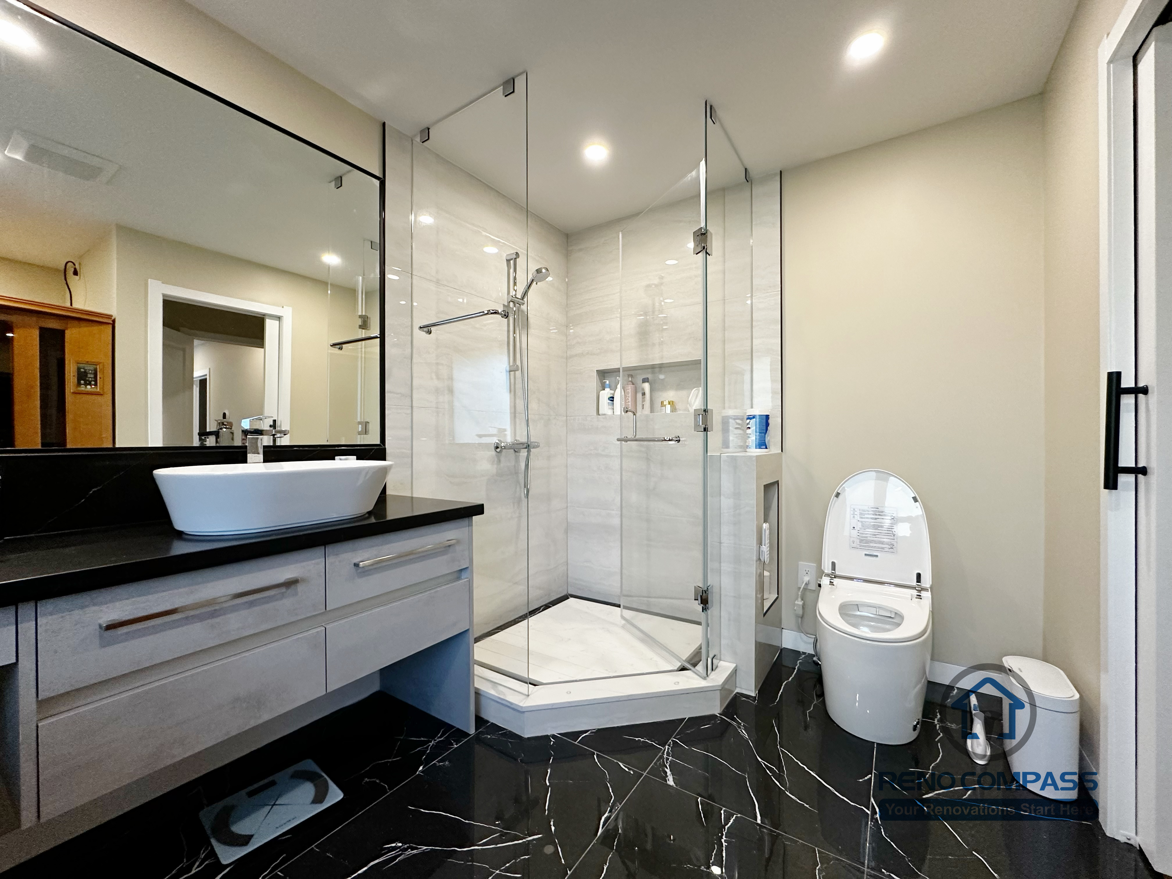 Modern bathroom completed as part of a North York interior renovation. This space features a frameless glass shower, large-format wall tiles, black marble-look flooring, and a custom vanity with vessel sink. Designed for durability, comfort, and clean visual balance by a professional Toronto renovation company.