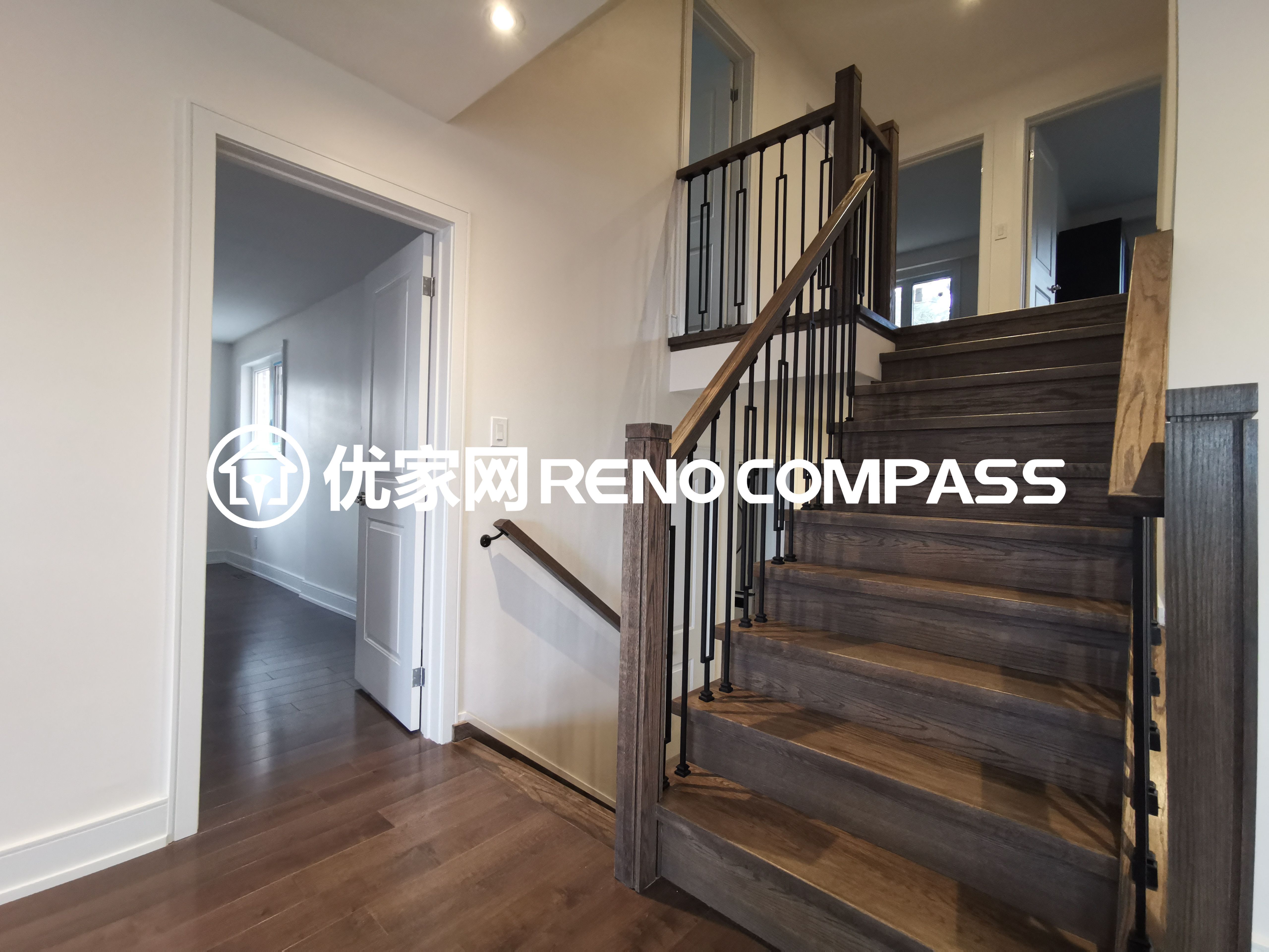 This image highlights a modern staircase completed as part of a North York interior renovation project. The staircase features natural wood treads paired with sleek black metal railings, creating a clean and contemporary contrast. The minimalist railing design enhances visual openness while maintaining safety and durability. Seamlessly integrated with the surrounding hardwood flooring, this staircase design reflects precise craftsmanship and thoughtful material selection, adding both architectural character and functional value to the overall interior renovation.