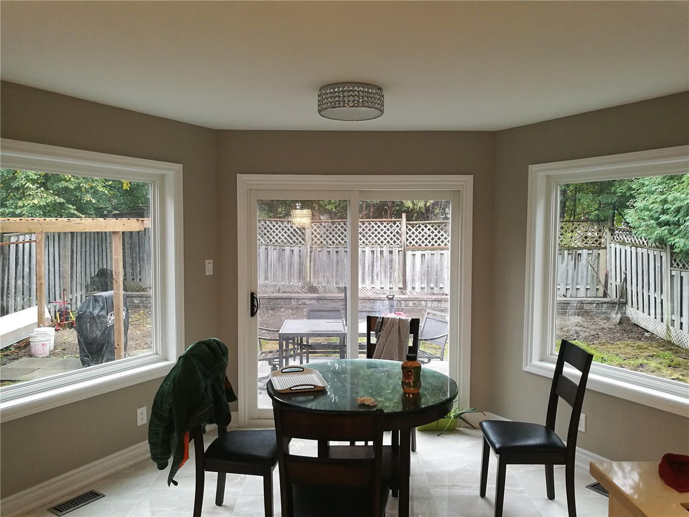 This Newmarket interior renovation features a bright breakfast nook enhanced by large bay windows and direct access to the backyard patio. Natural light, clean wall finishes, and updated flooring create a warm and functional dining space, showcasing the thoughtful layout and craftsmanship of a professional Toronto renovation company.
