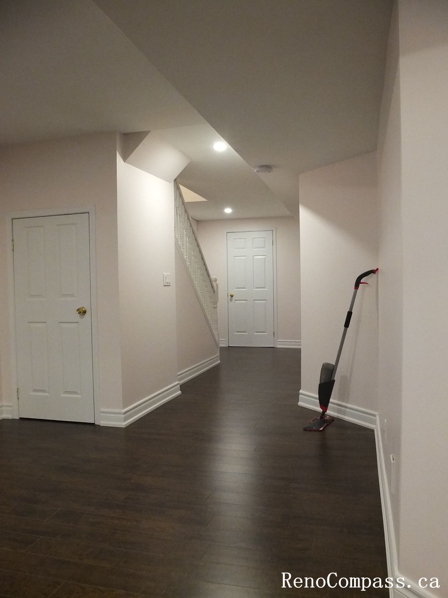 Professional basement renovation in Newmarket featuring an extended corridor layout, recessed ceiling lighting, clean white doors and trim, and rich dark hardwood flooring. This lower-level upgrade was completed by an experienced Toronto Renovation Company to maximize space flow and improve overall functionality.