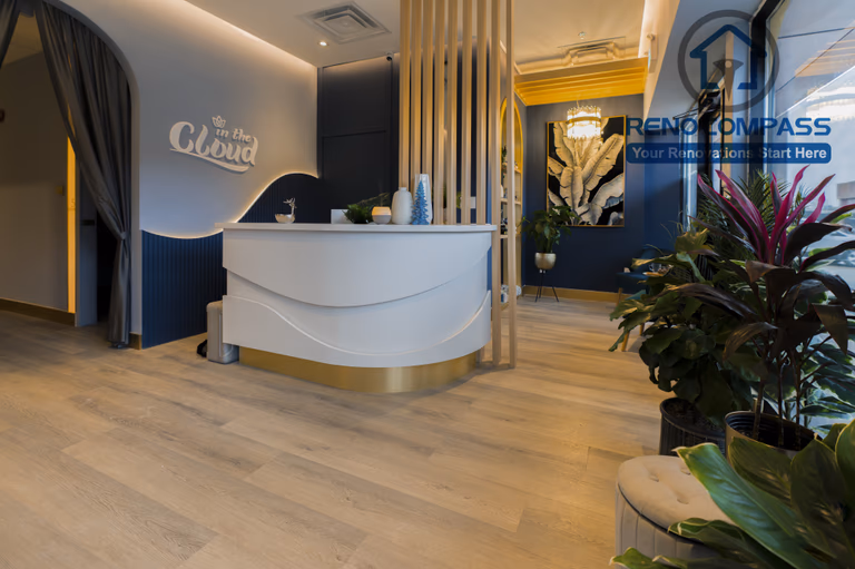 Custom reception desk detail completed as part of a North York beauty salon renovation. This image highlights curved millwork, soft ambient lighting, vertical wood slat accents, and integrated brand signage. The design enhances visual identity while maintaining smooth client flow and a calm, upscale atmosphere, delivered by a professional Toronto renovation company.