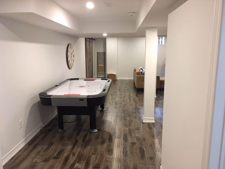 This Richmond Hill basement renovation features a spacious and functional recreation area designed for entertainment and family activities. The finished basement includes durable modern flooring, upgraded recessed lighting, and an open layout perfect for games and gatherings. This well-designed basement space enhances comfort, usability, and overall home value with a clean and contemporary finish.