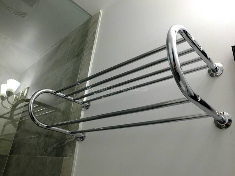 This North York bathroom renovation detail highlights a modern chrome wall-mounted towel rack installed beside a custom glass shower enclosure. Completed by a professional Toronto renovation company, the project emphasizes functional upgrades, durable hardware, and clean contemporary finishes to enhance everyday comfort while maintaining a sleek and organized bathroom space.