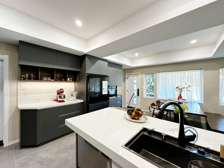 Modern kitchen completed as part of a North York interior renovation. This space features a large central island with integrated sink, custom cabinetry, built-in appliances, and clean-lined finishes. The open layout connects seamlessly with the dining area, enhancing functionality and everyday flow. Designed and built by a professional Toronto renovation company.