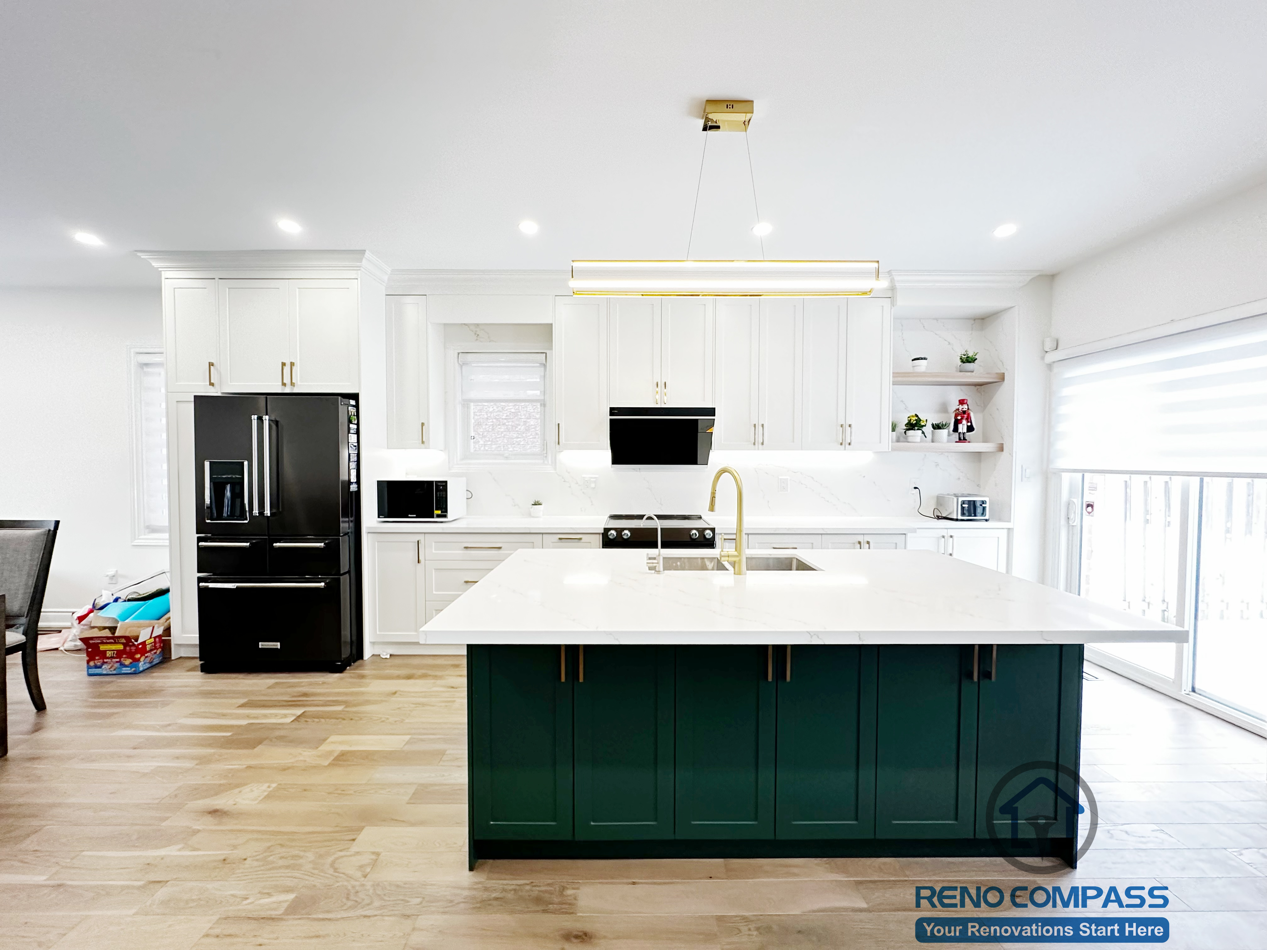 Interior renovation in Markham featuring a custom kitchen with full-height white cabinetry, a bold green island, quartz countertops, and modern pendant lighting. The design balances visual contrast with functionality, creating a bright and efficient central living space.