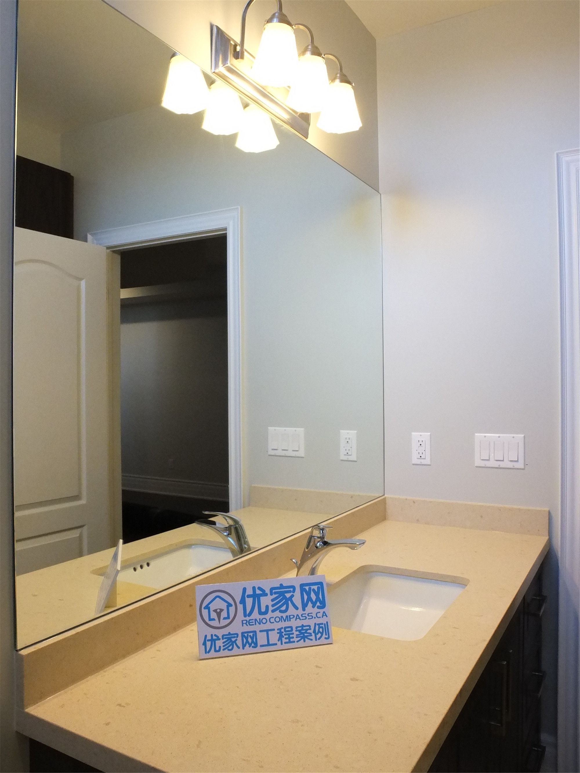 This Richmond Hill basement renovation features a modern bathroom vanity with a quartz countertop, large mirror, and stylish overhead lighting. The clean design and warm lighting enhance both functionality and aesthetics, creating a bright and polished bathroom space.