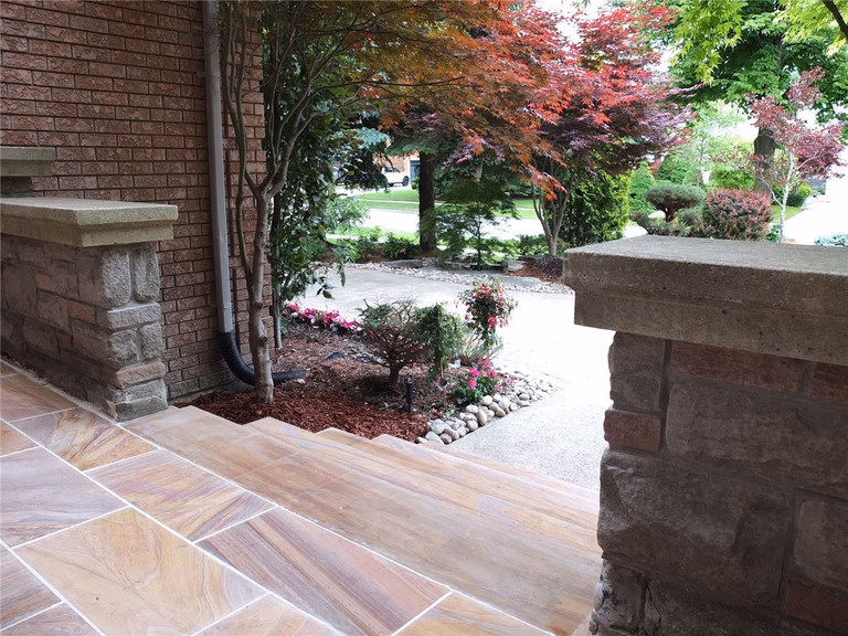 This Richmond Hill front entrance renovation showcases a newly installed interlocking stone porch with durable natural-tone tiles and clean modern finishing. The upgraded entrance landing improves safety, drainage, and curb appeal while complementing the home’s brick exterior and stone pillars. Completed by a trusted Toronto renovation company, this landscaping and interlocking project delivers a refined, long-lasting front entry designed for both functionality and visual impact