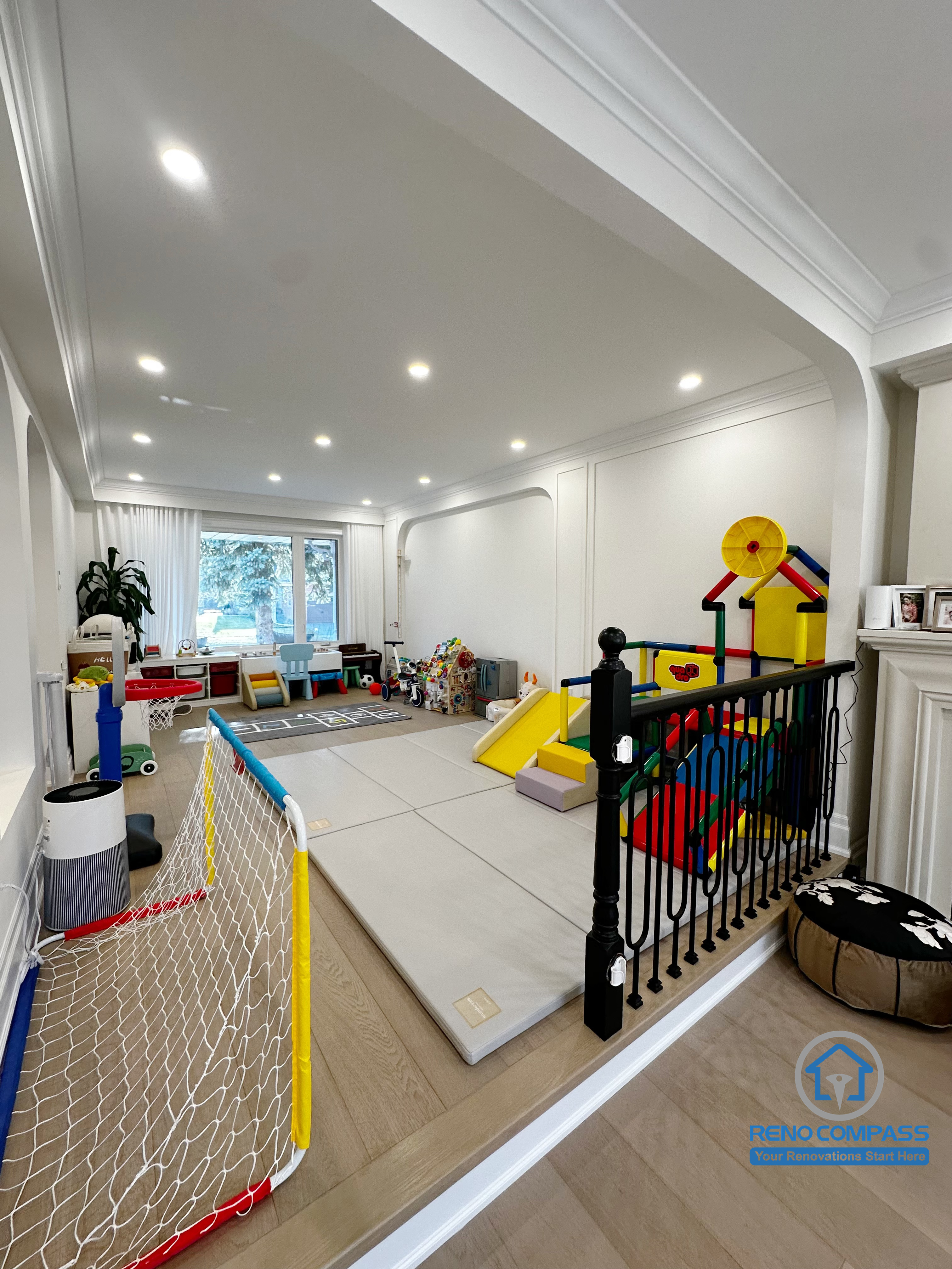 This Markham interior renovation was designed with everyday family life in mind, transforming the main living area into a flexible, child-friendly space that supports both play and relaxation. The open layout allows parents to maintain clear sightlines across the room while creating a safe and comfortable area for children’s activities.

Arched openings and consistent ceiling details help connect different zones of the home, while layered recessed lighting ensures the space remains bright and functional throughout the day. The combination of soft play areas and durable flooring makes the room adaptable as family needs evolve over time.

By balancing openness, safety, and long-term usability, this interior renovation creates a welcoming environment that works seamlessly for modern family living in Markham.