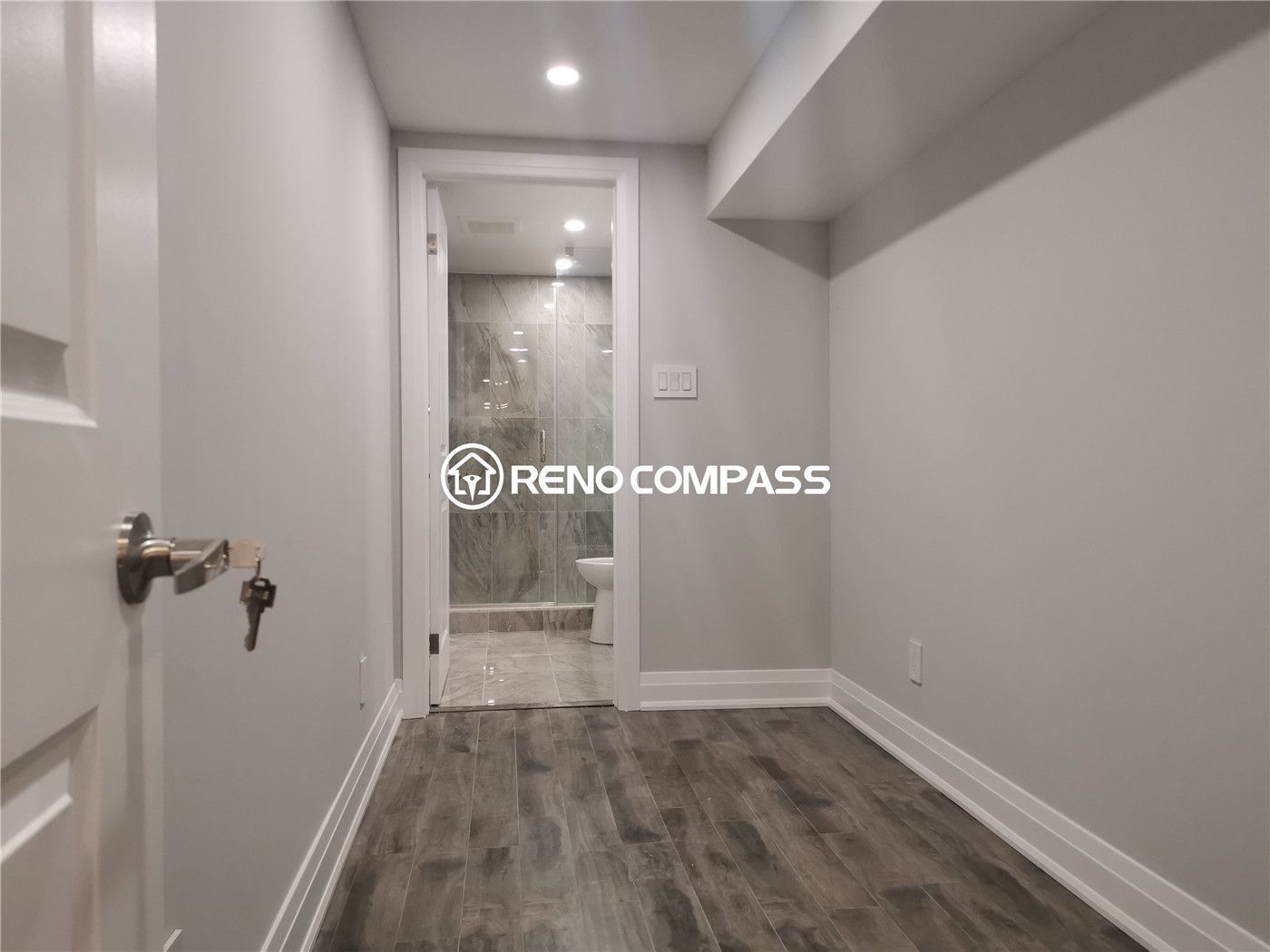 This Markham basement renovation showcases a newly finished bedroom area with waterproof vinyl plank flooring, recessed pot lighting, and a clean modern layout leading to a fully upgraded bathroom. The neutral wall tones and durable flooring create a comfortable, low-maintenance living space ideal for extended family use or rental potential. Careful finishing details, including baseboards and lighting, enhance both functionality and visual appeal. Completed by a professional Toronto renovation company, this basement upgrade highlights quality craftsmanship and practical design tailored for modern homes in the Greater Toronto Area.