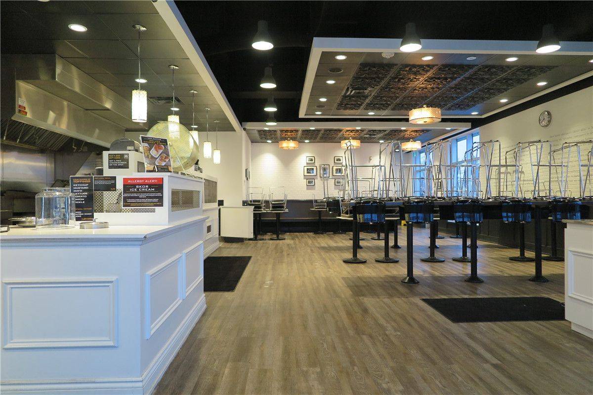 This Toronto commercial restaurant renovation showcases the fully completed dining area and open-concept service layout by Reno Compass Inc. The project focused on maximizing operational flow while creating a welcoming customer environment.

Key upgrades included custom front counters, integrated commercial kitchen access, modern suspended ceiling features with recessed and pendant lighting, and durable wood-look vinyl flooring designed for high-traffic restaurant use. The spacious dining area layout ensures smooth circulation between service stations and seating zones.

By combining functionality with clean architectural lines, this project reflects Reno Compass Inc.’s expertise in delivering professional restaurant renovations across Toronto, built to meet commercial standards and long-term business performance.