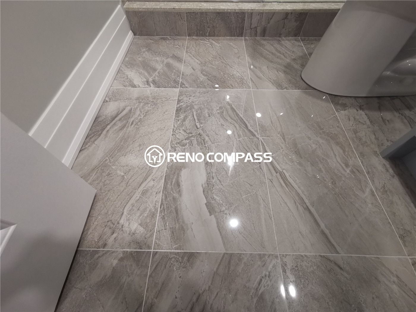 This Markham basement renovation features premium grey porcelain tile flooring installed in the bathroom area, offering a sleek marble-look finish and high durability for daily use. The reflective tile surface enhances lighting and creates a clean, modern atmosphere while ensuring water resistance and easy maintenance. Completed by a professional Toronto renovation company, this basement bathroom upgrade highlights precise tile installation, detailed finishing, and functional design tailored for long-lasting performance in residential basement spaces.