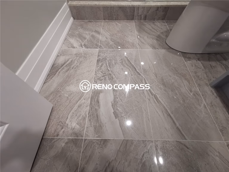 This Markham basement renovation features premium grey porcelain tile flooring installed in the bathroom area, offering a sleek marble-look finish and high durability for daily use. The reflective tile surface enhances lighting and creates a clean, modern atmosphere while ensuring water resistance and easy maintenance. Completed by a professional Toronto renovation company, this basement bathroom upgrade highlights precise tile installation, detailed finishing, and functional design tailored for long-lasting performance in residential basement spaces.