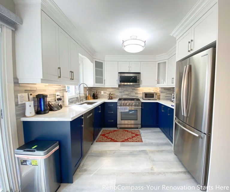 A modern U-shaped kitchen completed as part of a Newmarket interior renovation, featuring two-tone cabinetry, quartz countertops, stainless steel appliances, and a functional layout designed for daily use by a Toronto renovation company.