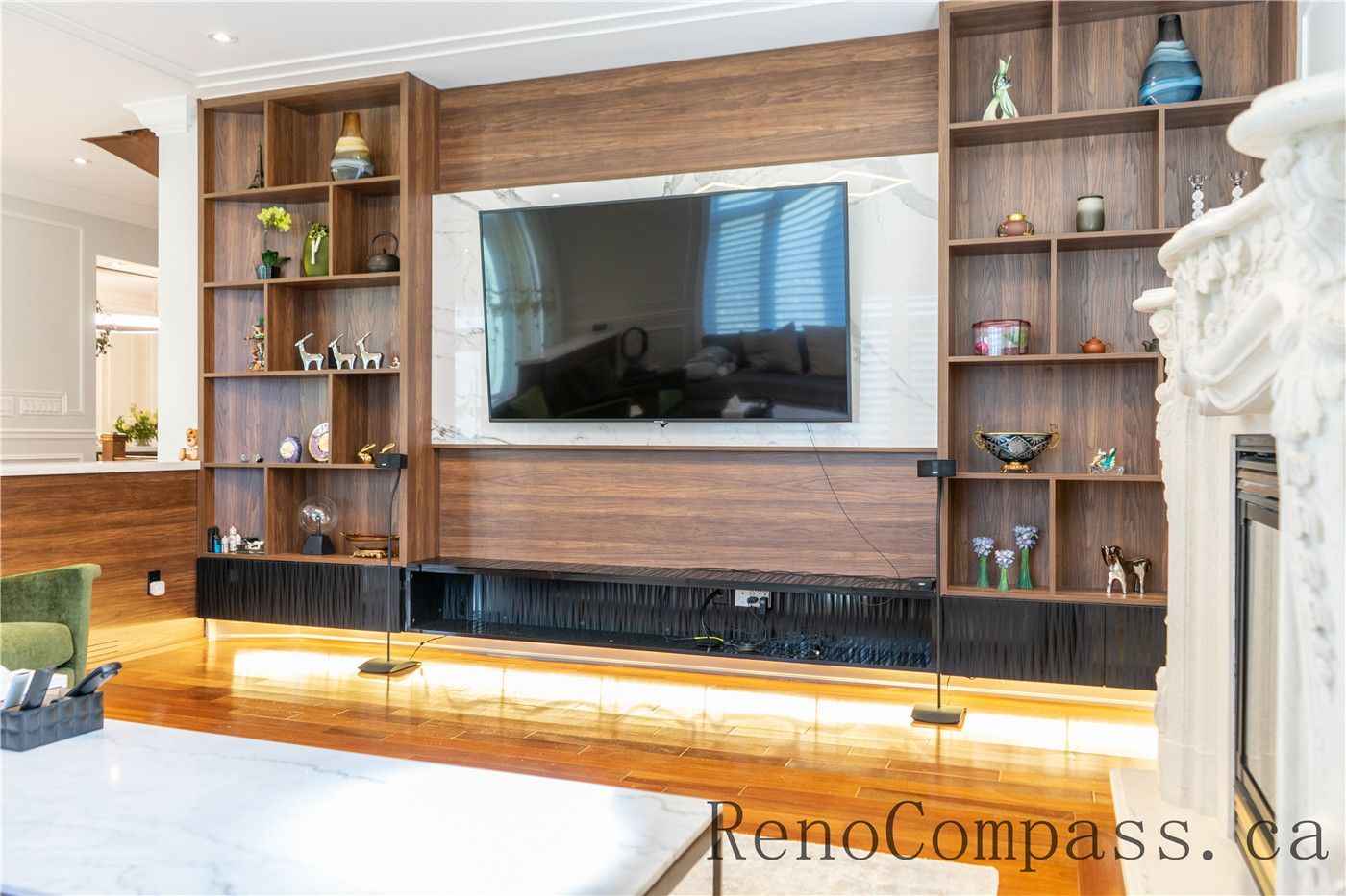 This Richmond Hill entire house renovation features a custom-built living room entertainment wall with wood paneling, integrated shelving, accent lighting, and a modern TV feature wall. Designed for both storage and visual impact, the space showcases detailed craftsmanship and functional layout planning by a trusted Toronto renovation company, creating a warm and elegant focal point for the home.
