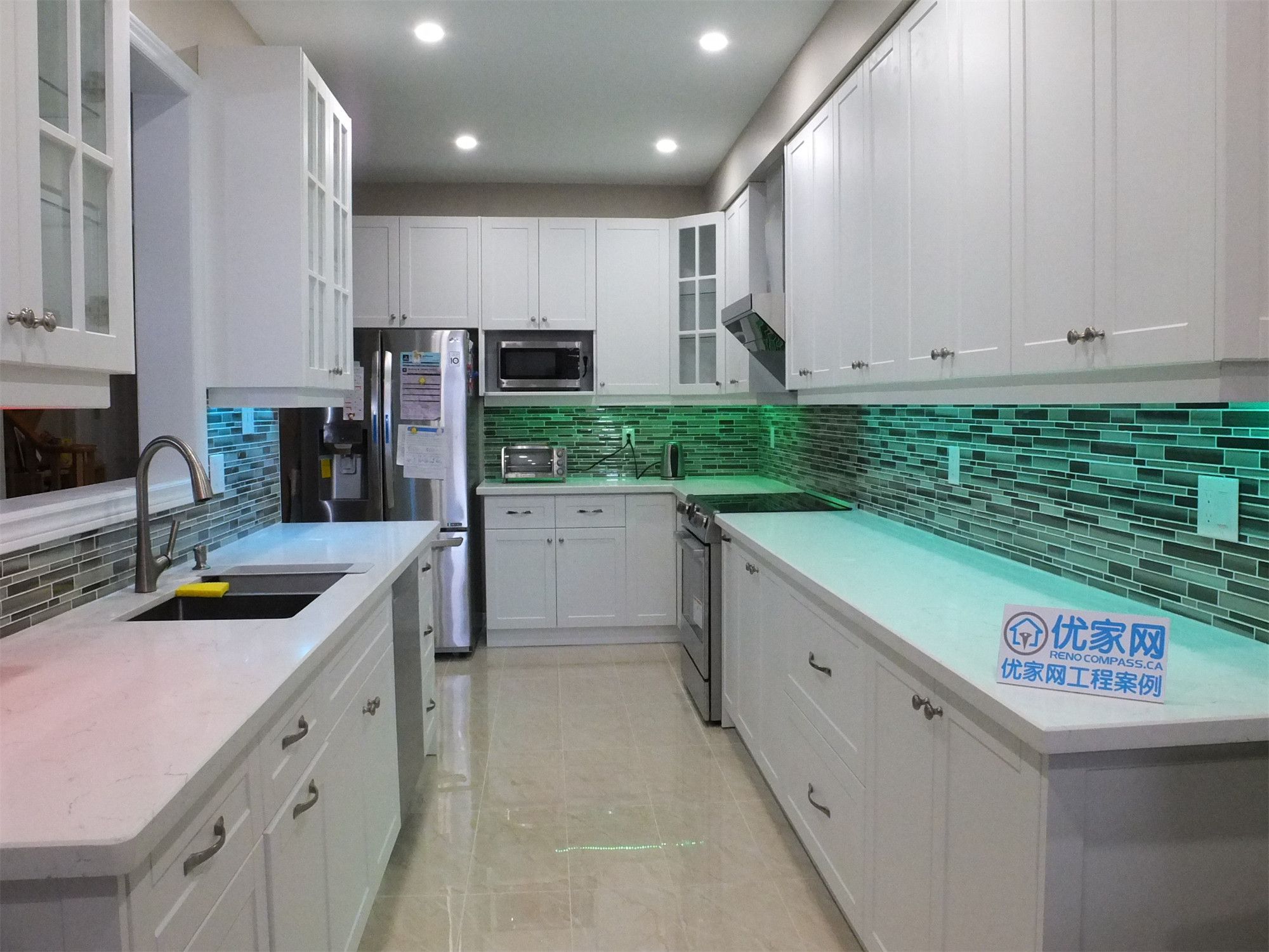 This Vaughan kitchen renovation showcases elegant white shaker cabinetry, quartz countertops, and a modern glass mosaic tile backsplash enhanced with soft LED under-cabinet lighting. The streamlined layout and bright finishes create a clean, contemporary cooking space. Completed by a professional Toronto renovation company, the design blends practical functionality with modern kitchen aesthetics.