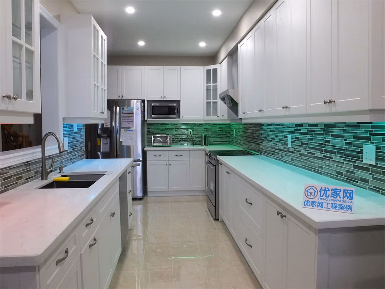 This Vaughan kitchen renovation showcases elegant white shaker cabinetry, quartz countertops, and a modern glass mosaic tile backsplash enhanced with soft LED under-cabinet lighting. The streamlined layout and bright finishes create a clean, contemporary cooking space. Completed by a professional Toronto renovation company, the design blends practical functionality with modern kitchen aesthetics.