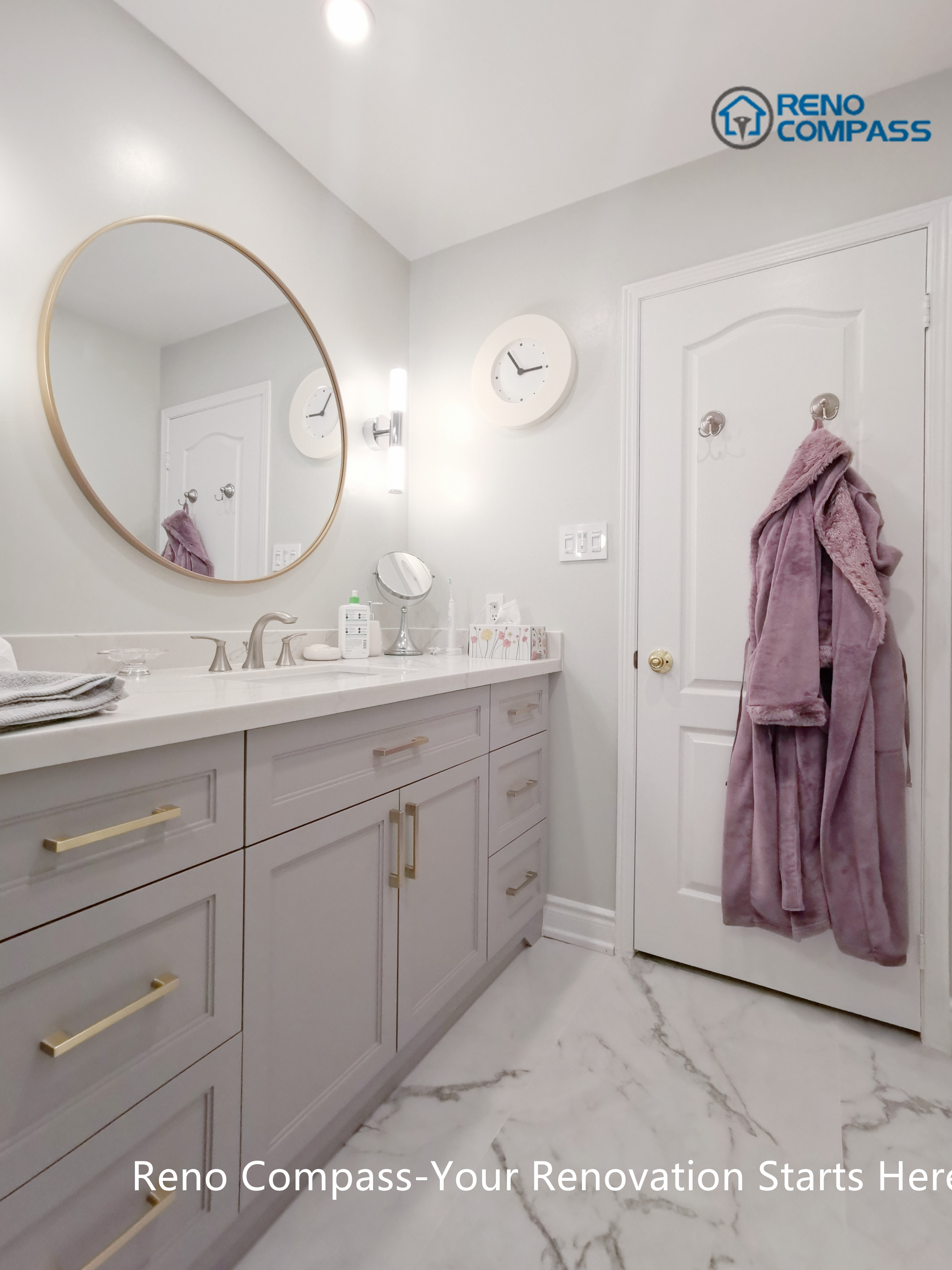 This Mississauga bathroom renovation features a custom vanity with soft grey cabinetry, brushed gold hardware, and a clean quartz countertop. A round framed mirror paired with vertical wall sconces provides balanced lighting for daily use while enhancing the overall elegance of the space. Thoughtful storage design and refined finishes reflect the attention to detail and craftsmanship expected from a professional Toronto renovation company.