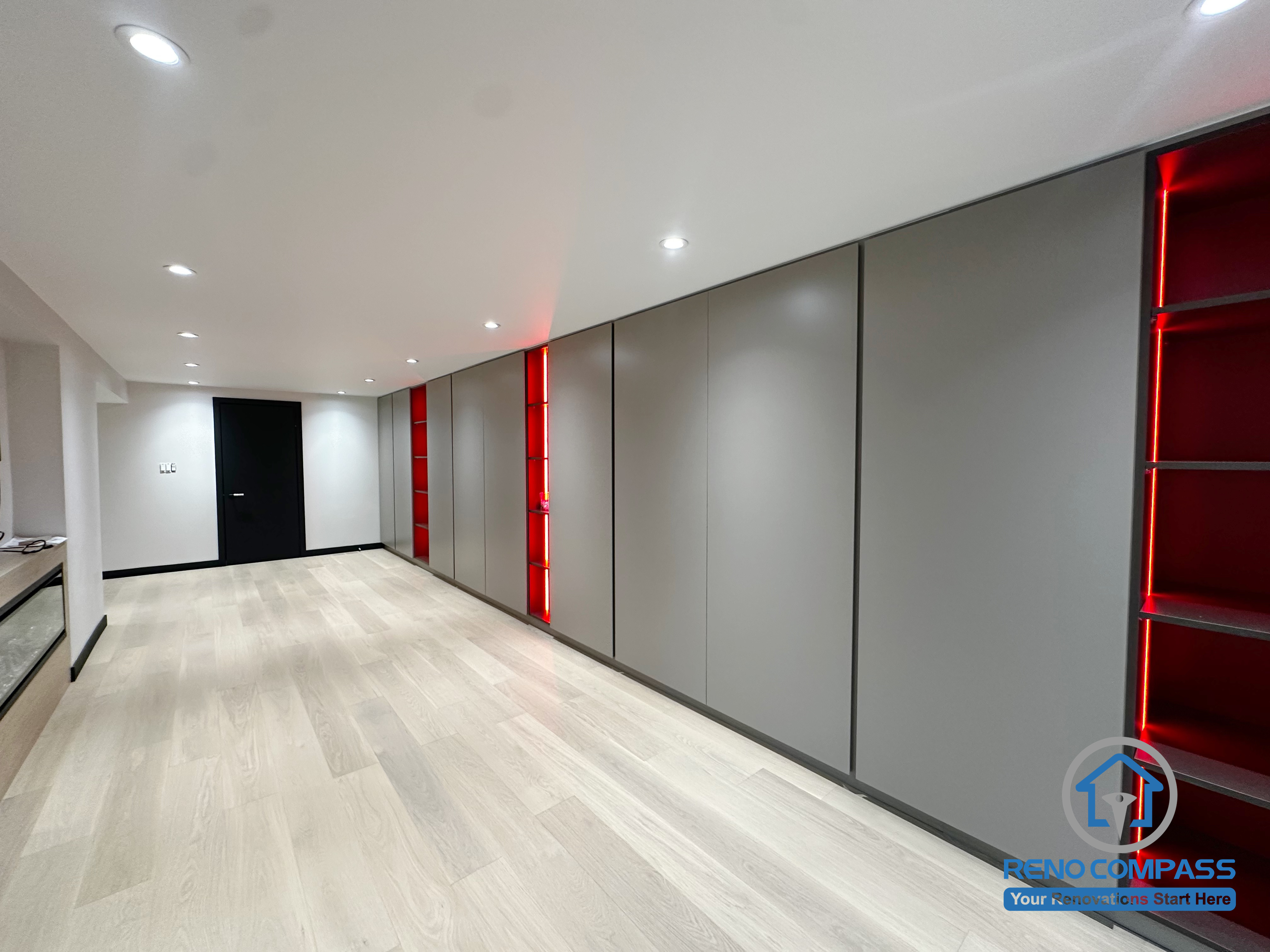 A sleek modern hallway featuring full-height storage panels paired with striking red LED-accented open shelving.
The clean grey cabinetry enhances the minimalist look, while the illuminated niches add depth, warmth, and a bold visual statement.
Perfectly balanced between function and aesthetics. 一条充满现代设计感的走廊，以整面通高收纳柜搭配红色LED灯光展示格为亮点。
灰色柜体简洁利落，灯光展示格为空间增添层次与视觉焦点。
功能与美感兼具，充满氛围感。