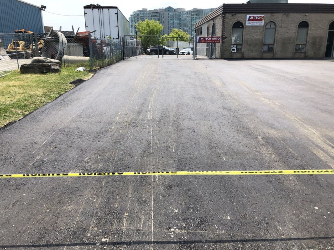 A high-quality asphalt paving installation completed as part of a comprehensive Toronto landscaping renovation. This image shows the smooth, finished surface of a wide driveway, highlighting professional workmanship and curb appeal enhancement.