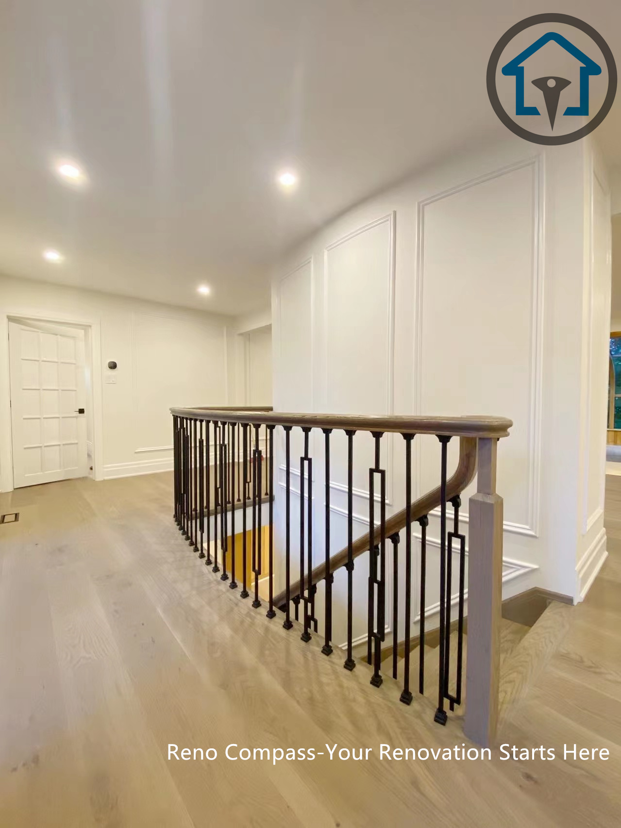 This North York house interior renovation features a refined upper hallway with custom wall paneling, wide-plank wood flooring, and a modern staircase railing. Recessed lighting and clean sightlines enhance circulation between levels, creating a bright and cohesive transition space that complements the home’s overall interior upgrade.