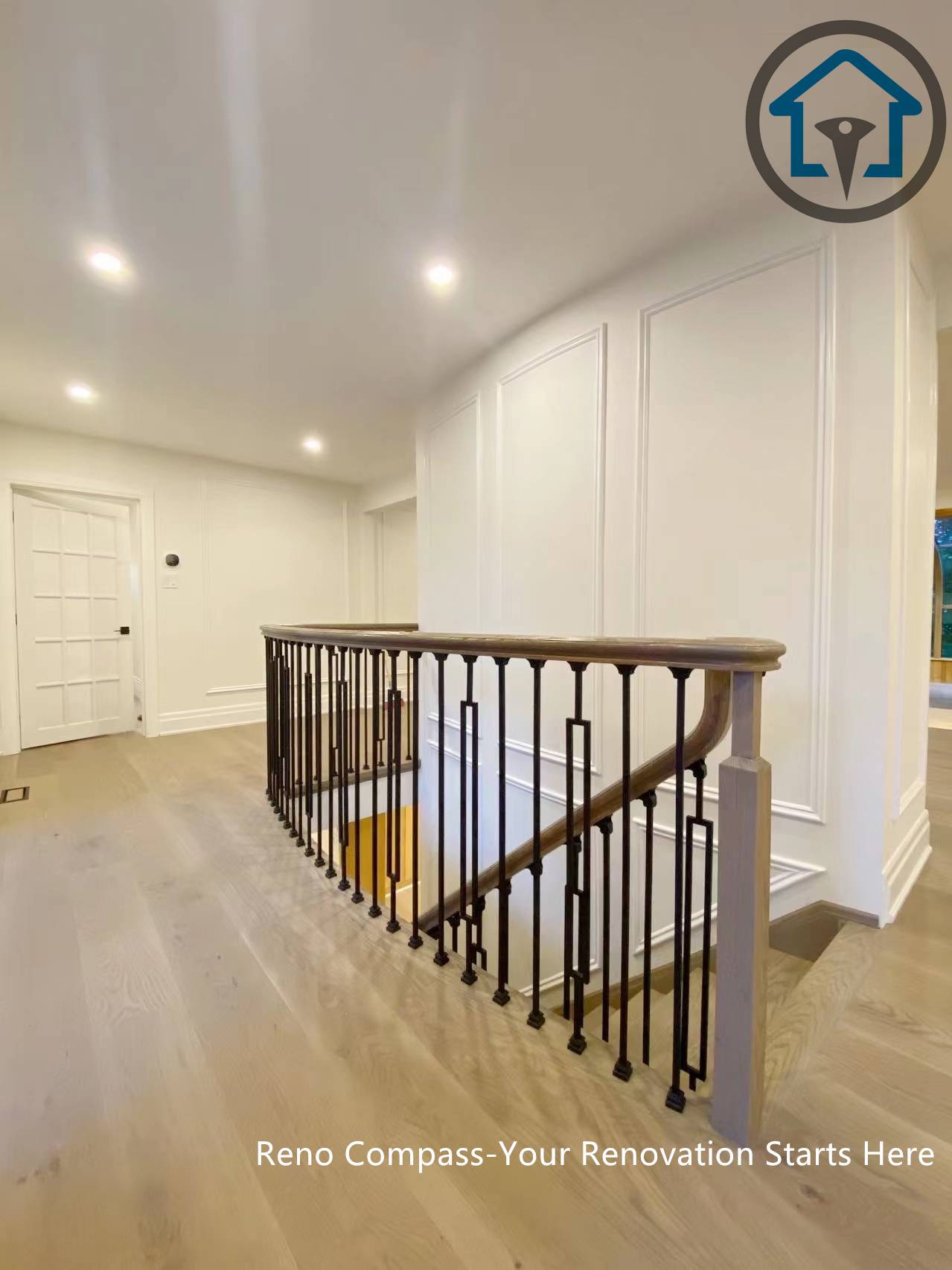This North York house interior renovation features a refined upper hallway with custom wall paneling, wide-plank wood flooring, and a modern staircase railing. Recessed lighting and clean sightlines enhance circulation between levels, creating a bright and cohesive transition space that complements the home’s overall interior upgrade.